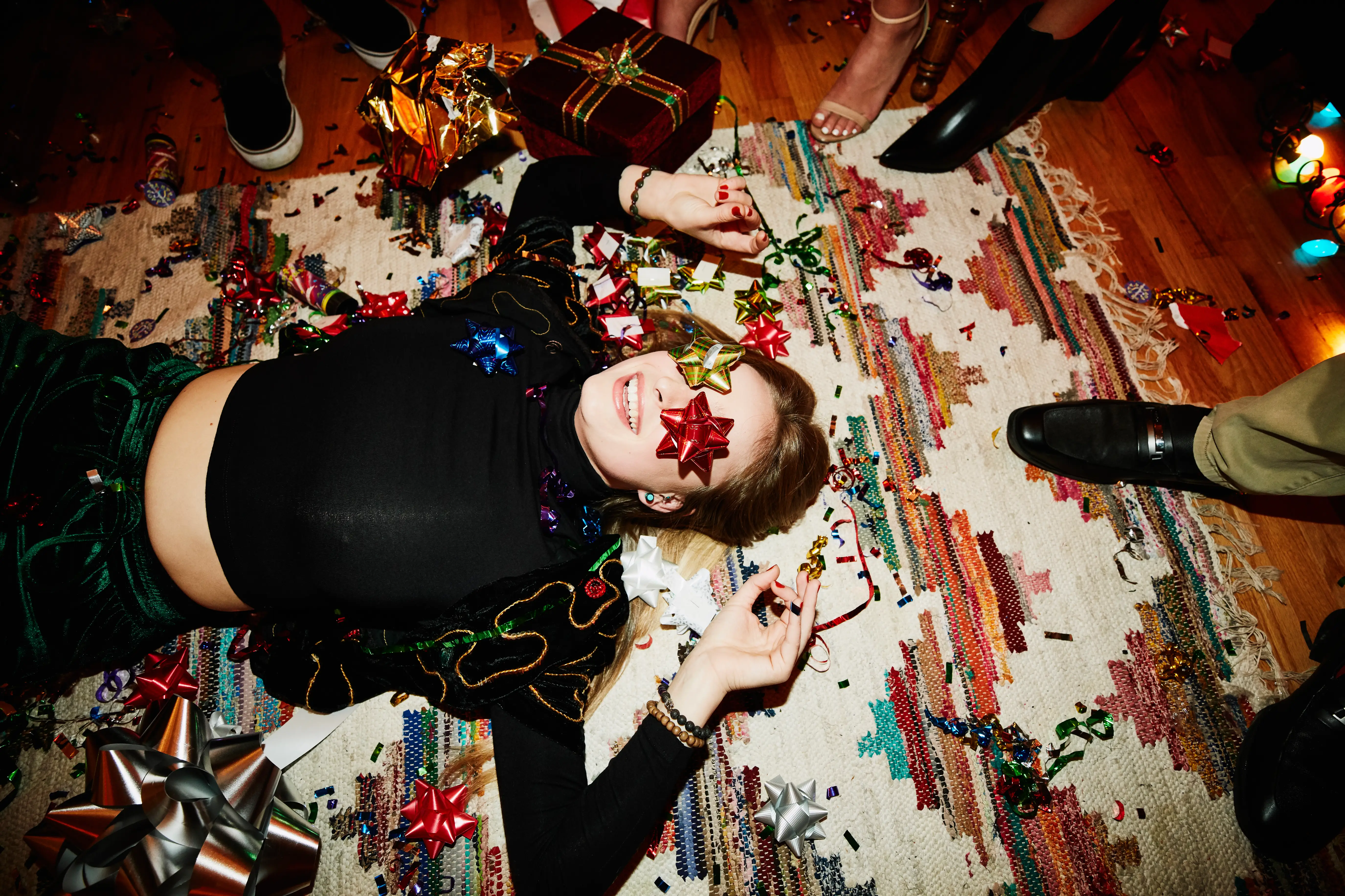 A woman lies on the floor at a festive holiday party