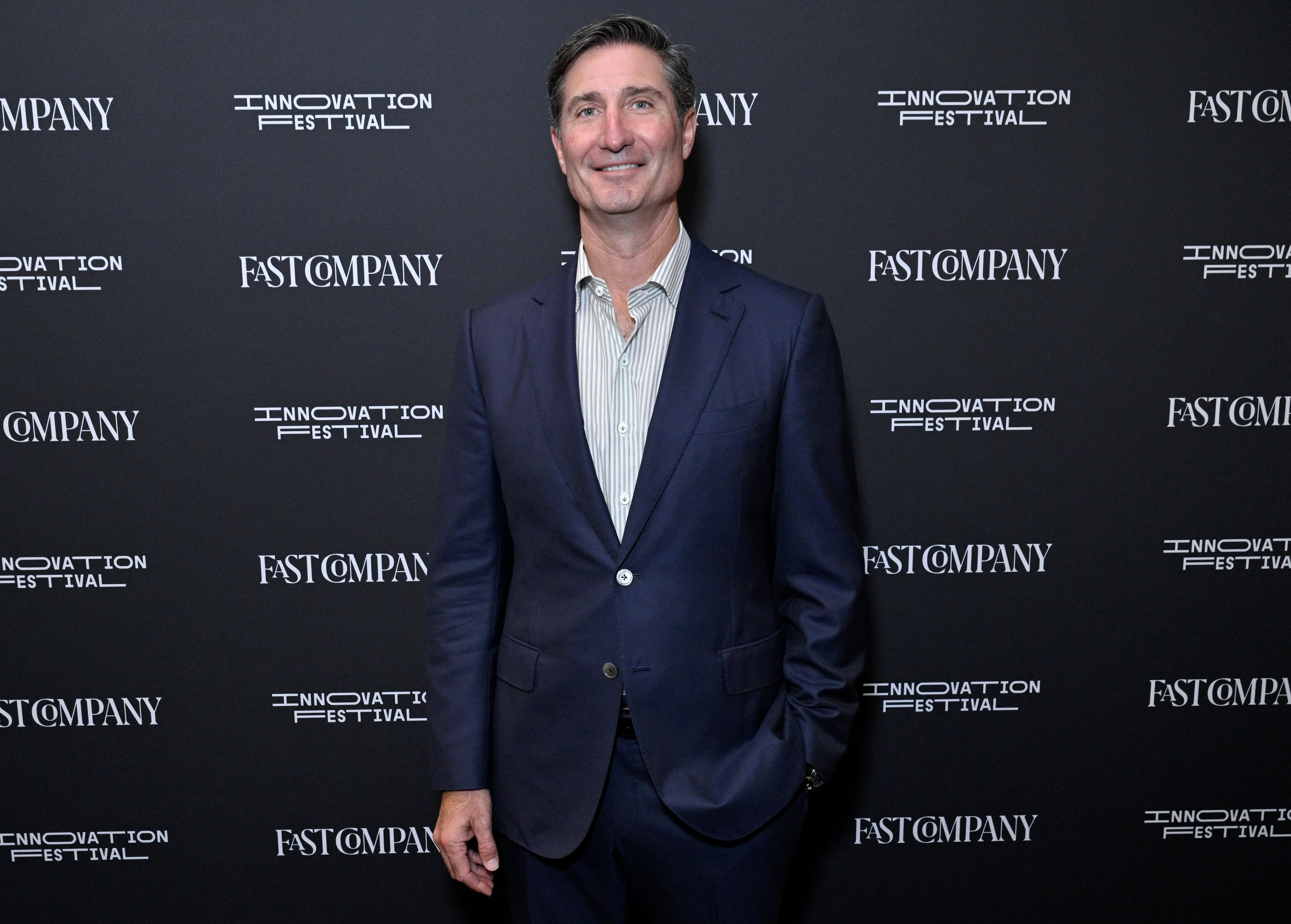Starbucks CEO Brian Niccol stands in front of a step-and-repeat banner featuring the Fast Company logo.