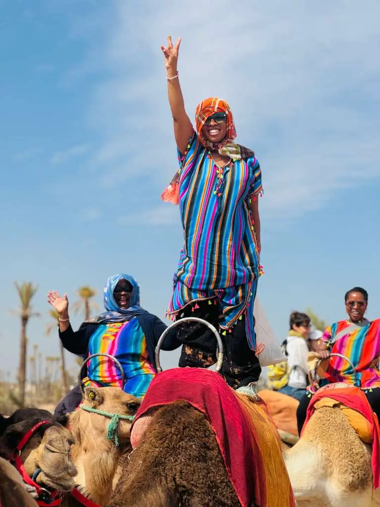 Standing while riding a camel with mom and sister in Municipalité de Marrakech, Morocco.