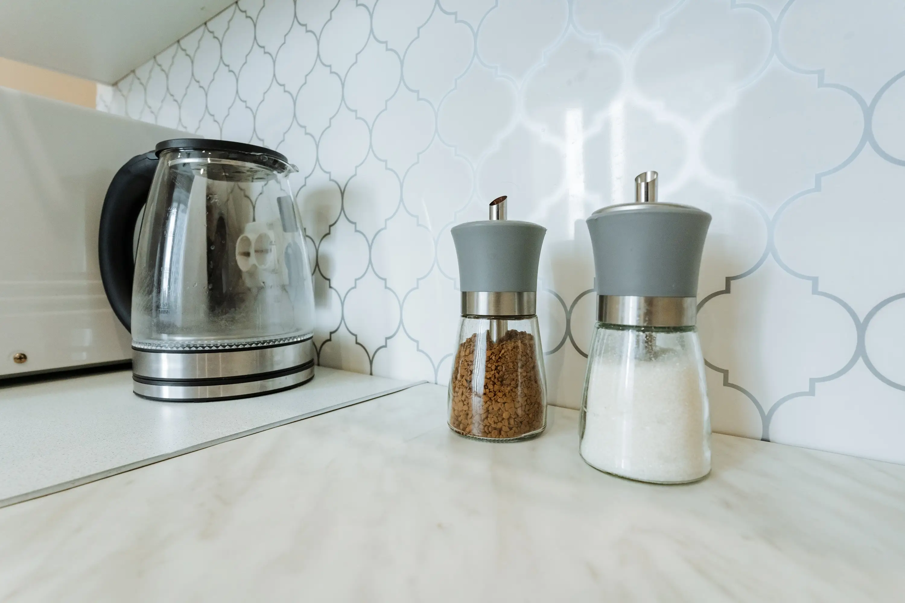 Geometric patterned backsplash in kitchen in white and silver