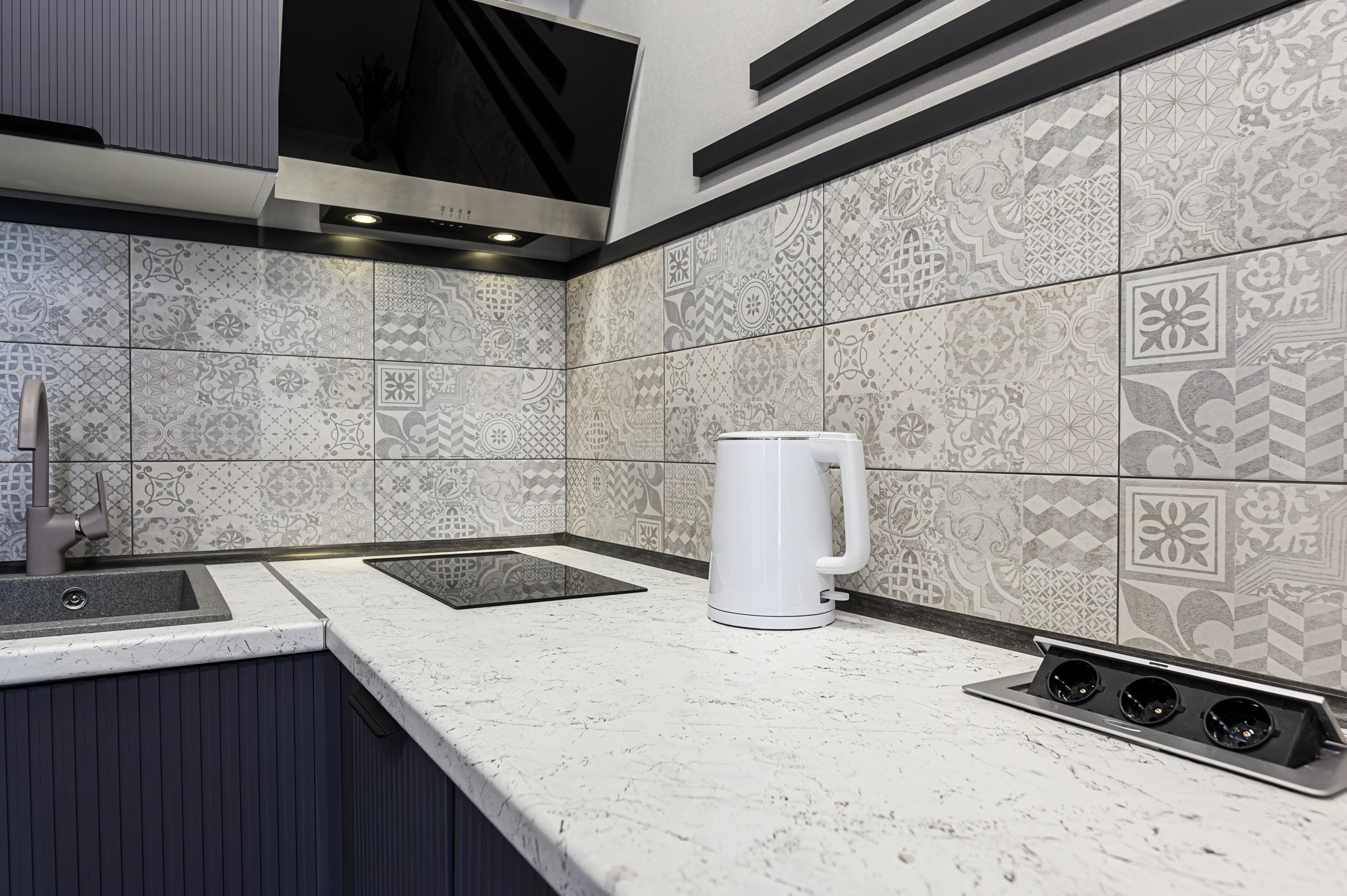 Kitchen with pop-up outlets coming from countertop, patterned backsplash