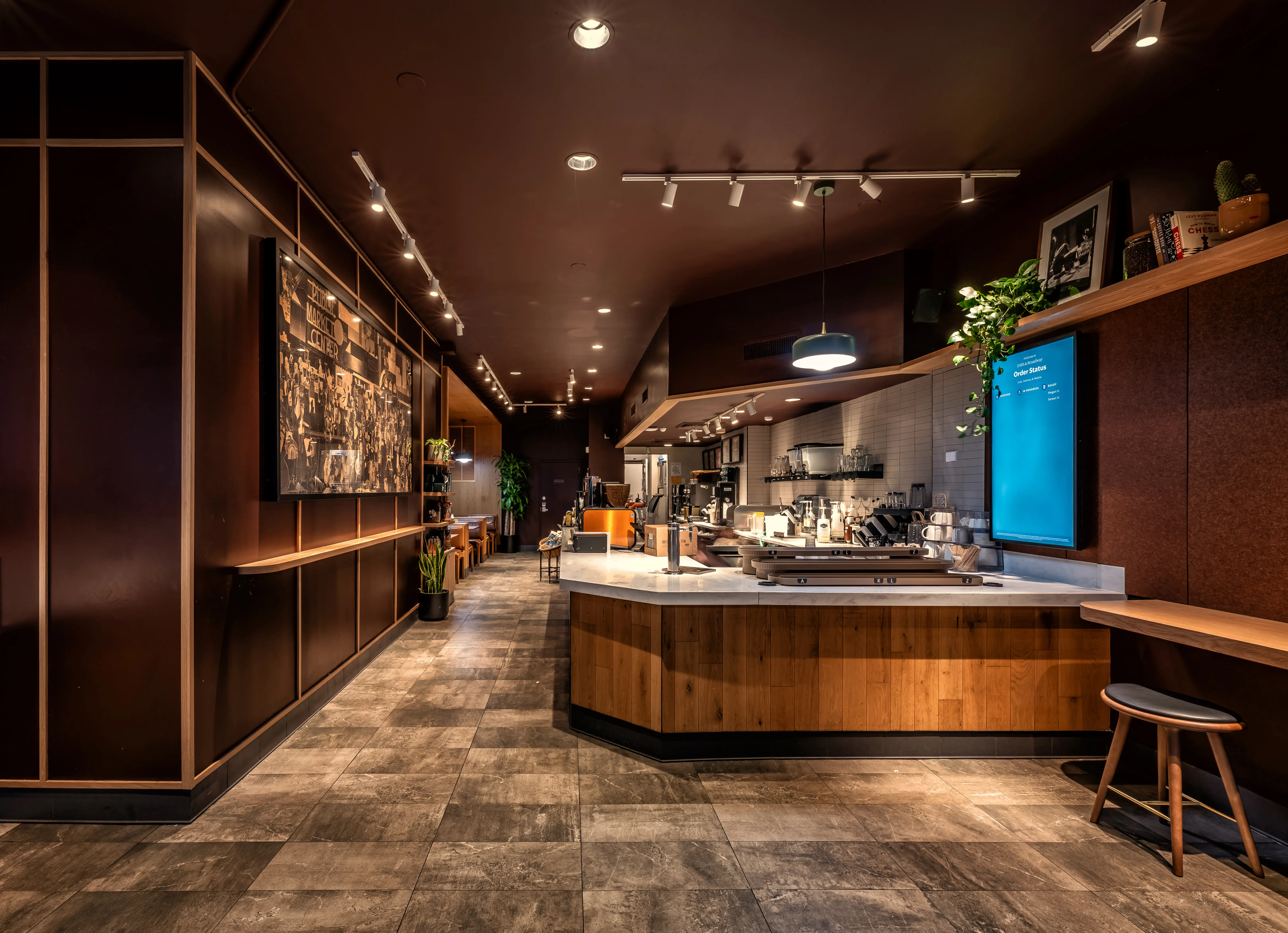 The interior of a refreshed Starbucks location, featuring brown walls and warm, dark wood accents.