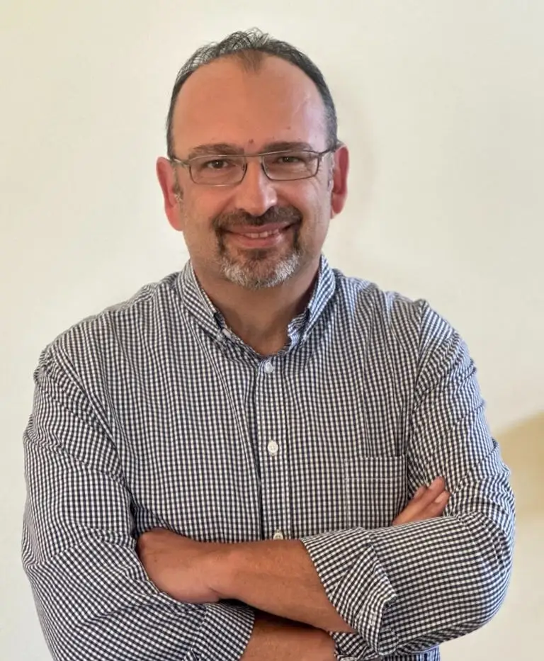 Sergio Avedian wears a pair of glasses and a blue and white checkered shirt while facing the camera.