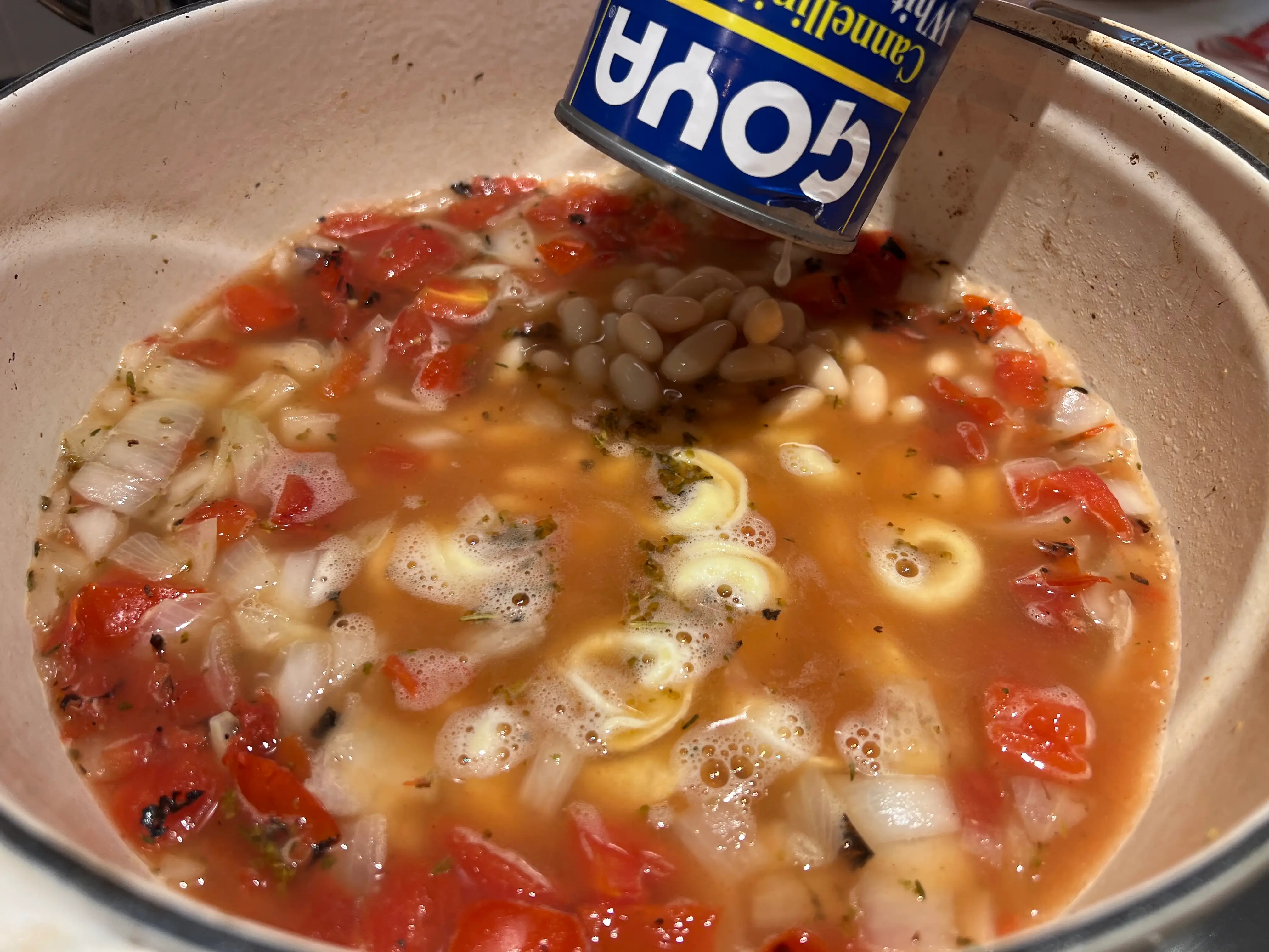 Goya cannellini beans being added to the soup.