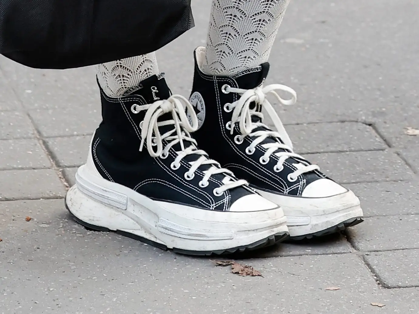 A close-up of black platform Converse sneakers.