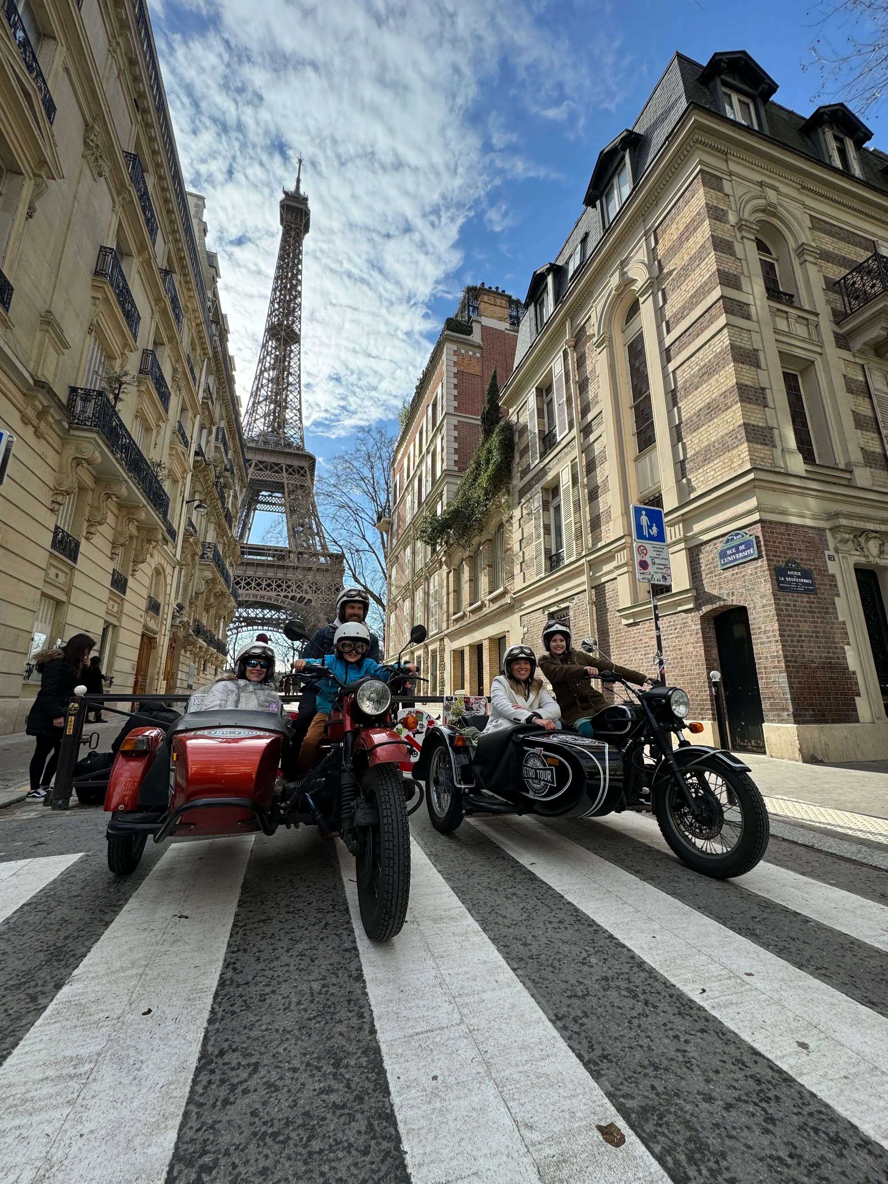 Family on motorbikes in Paris, France with the Eiffel Tower int he background.