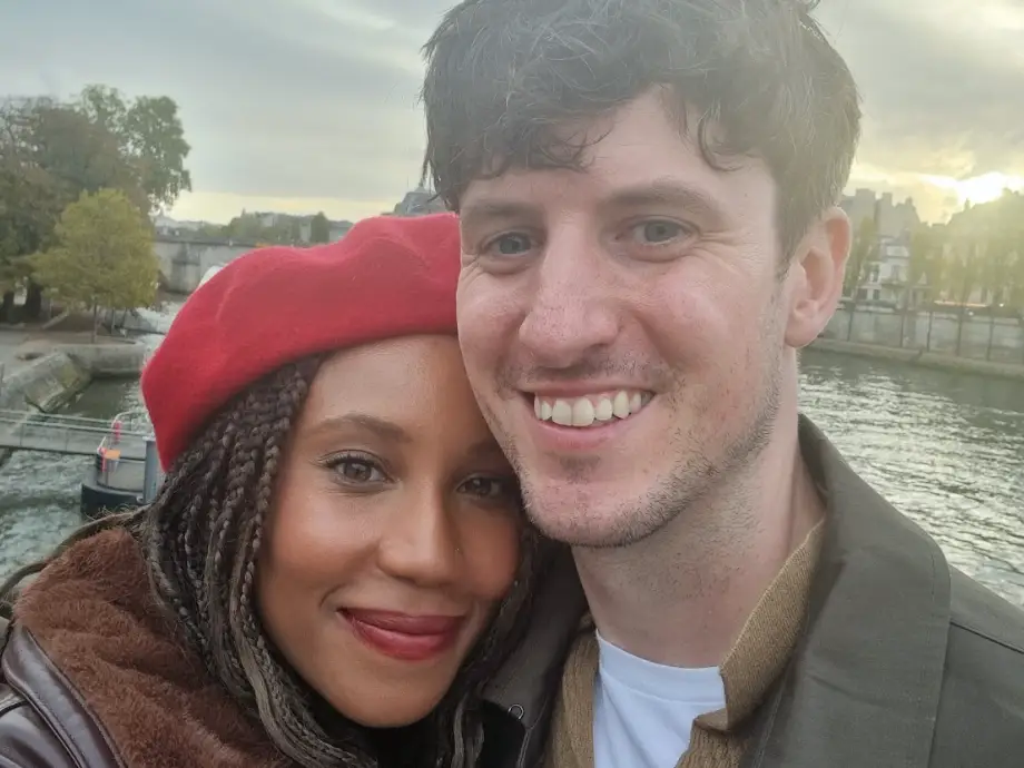 The writer and her husband posing in front of the water.