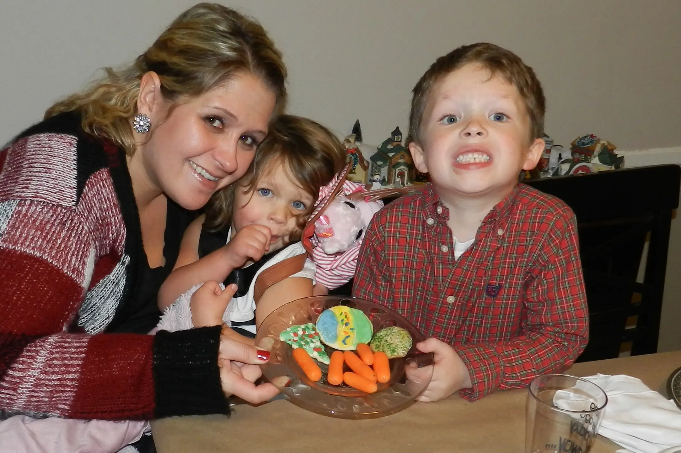 The author with her kids when they were preschool-age, they are holding a plate with baby carrots and cookies.