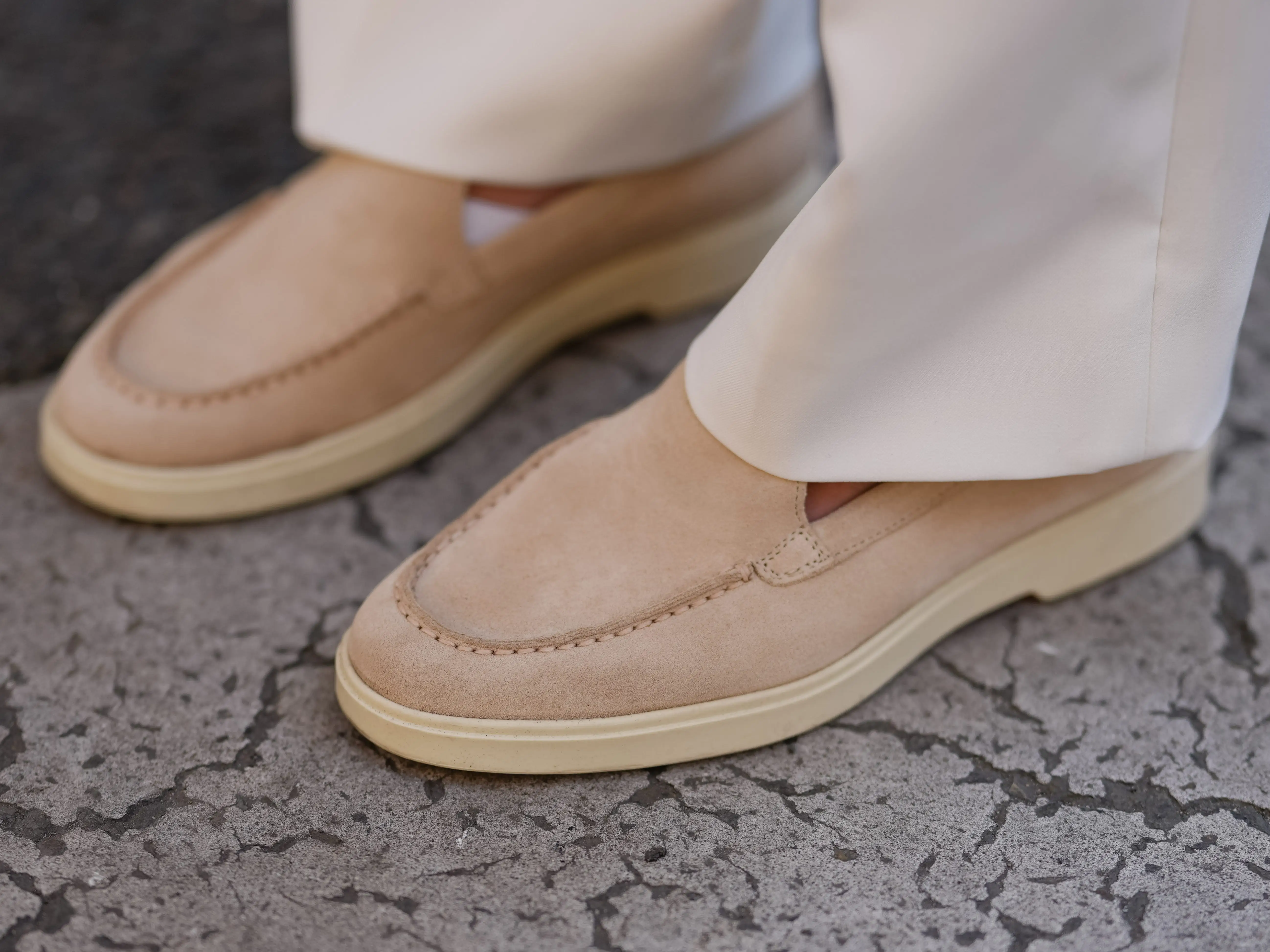 A close-up of beige loafers with a thick cream rubber sole.
