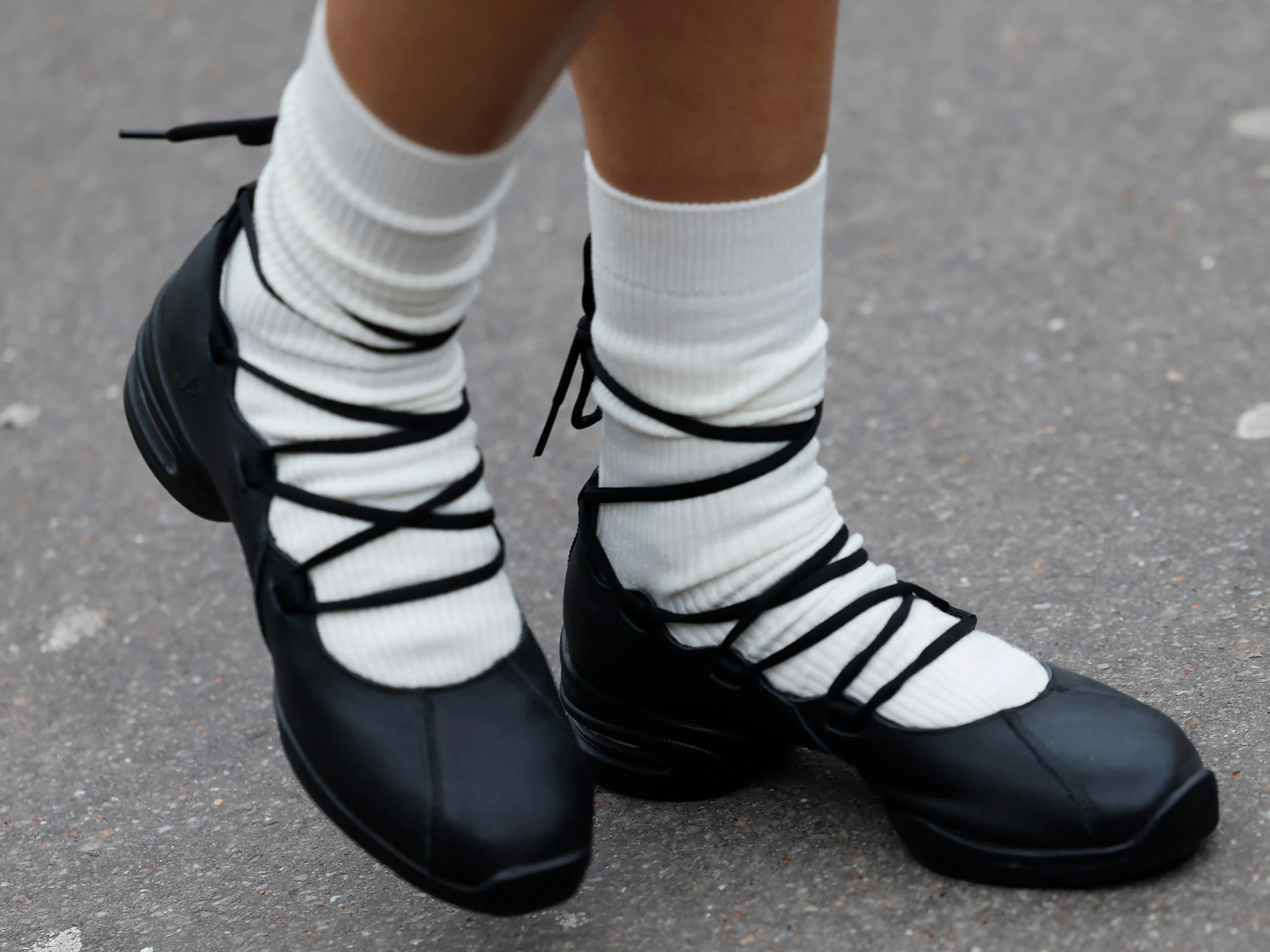 A close-up of black ballet sneakers.
