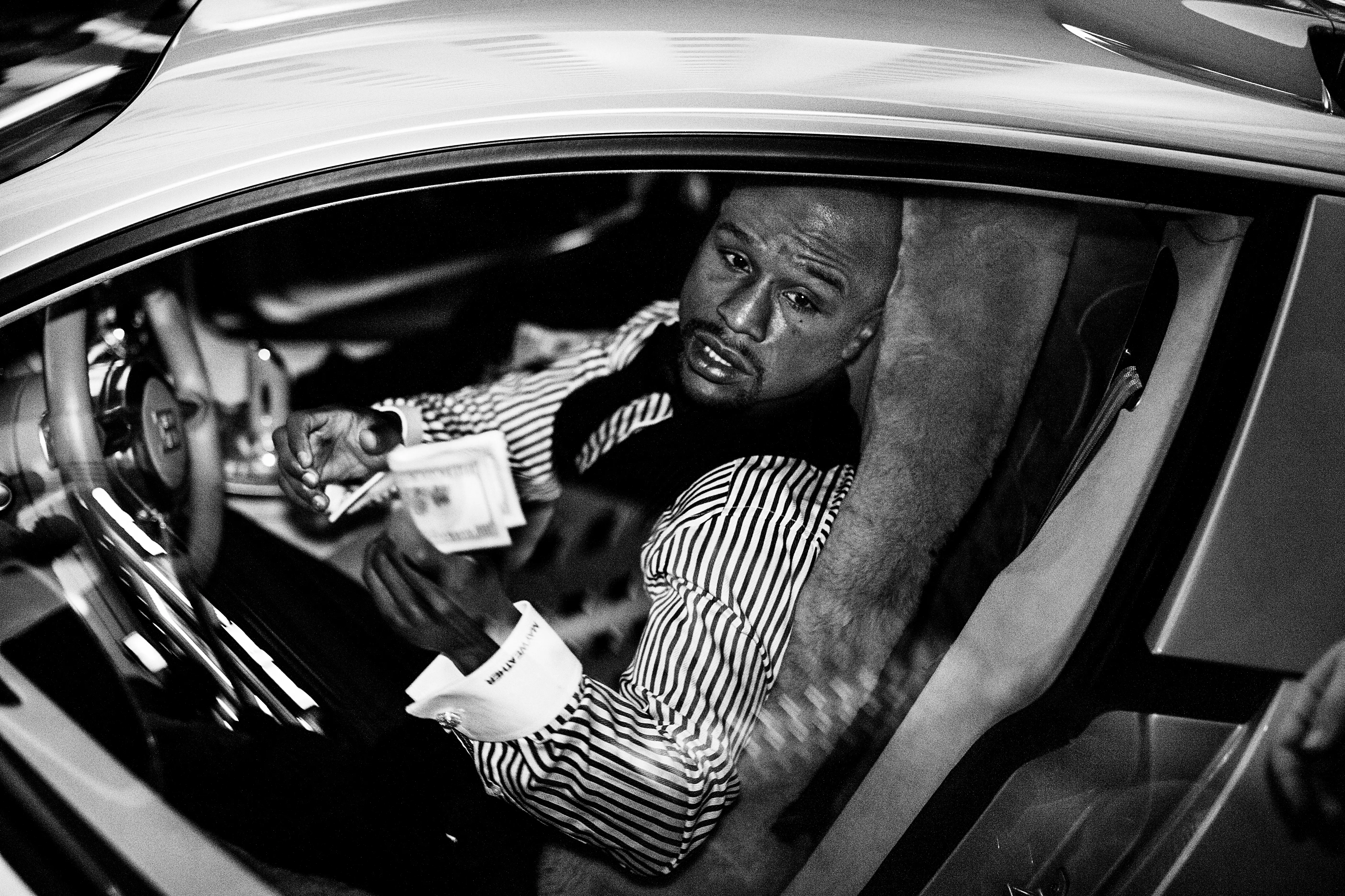 Floyd Mayweather tips a valet from his car in front of a casino.