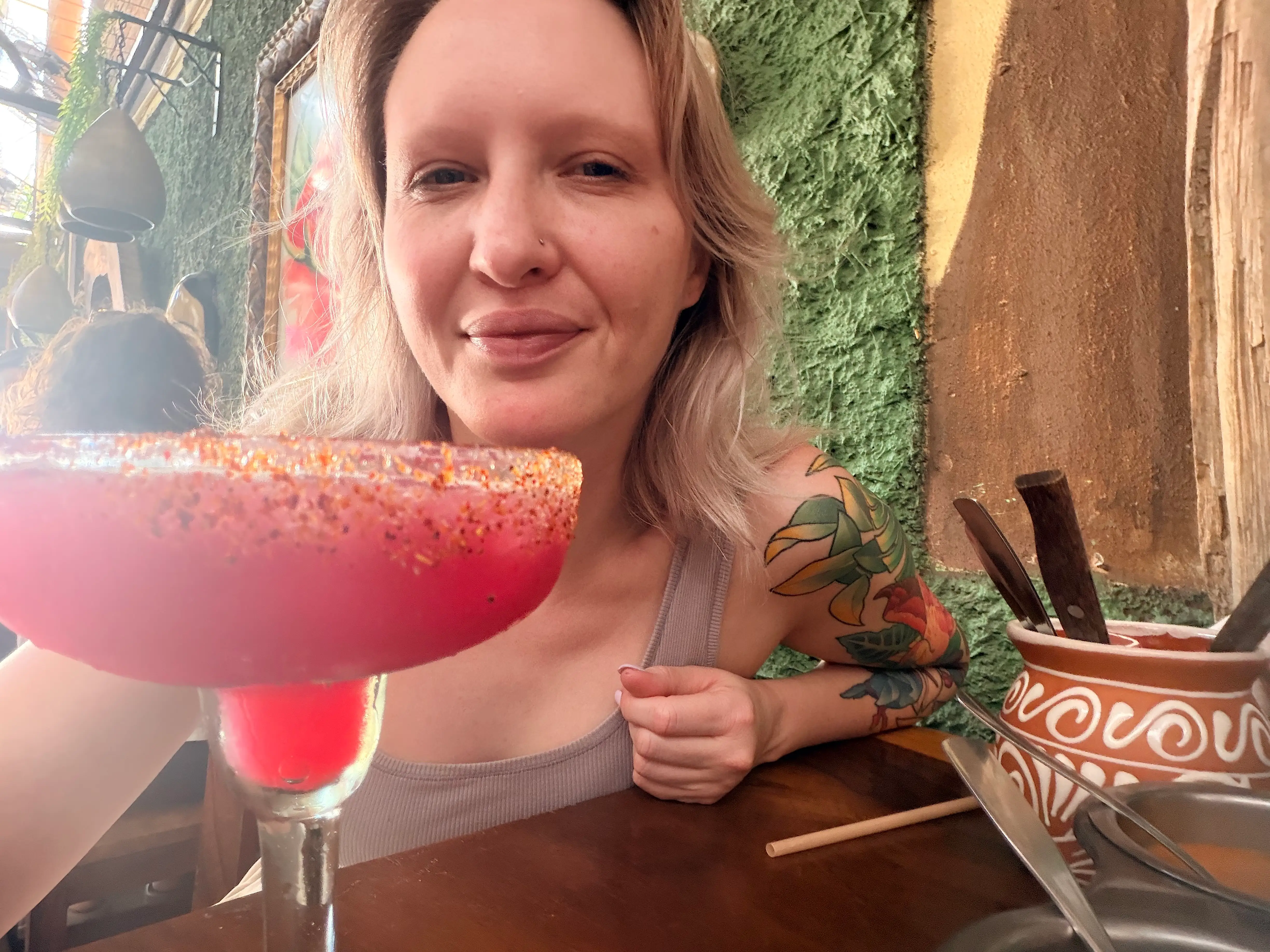 The author in Mexico with a pink cocktail in a glass with a salted rim.