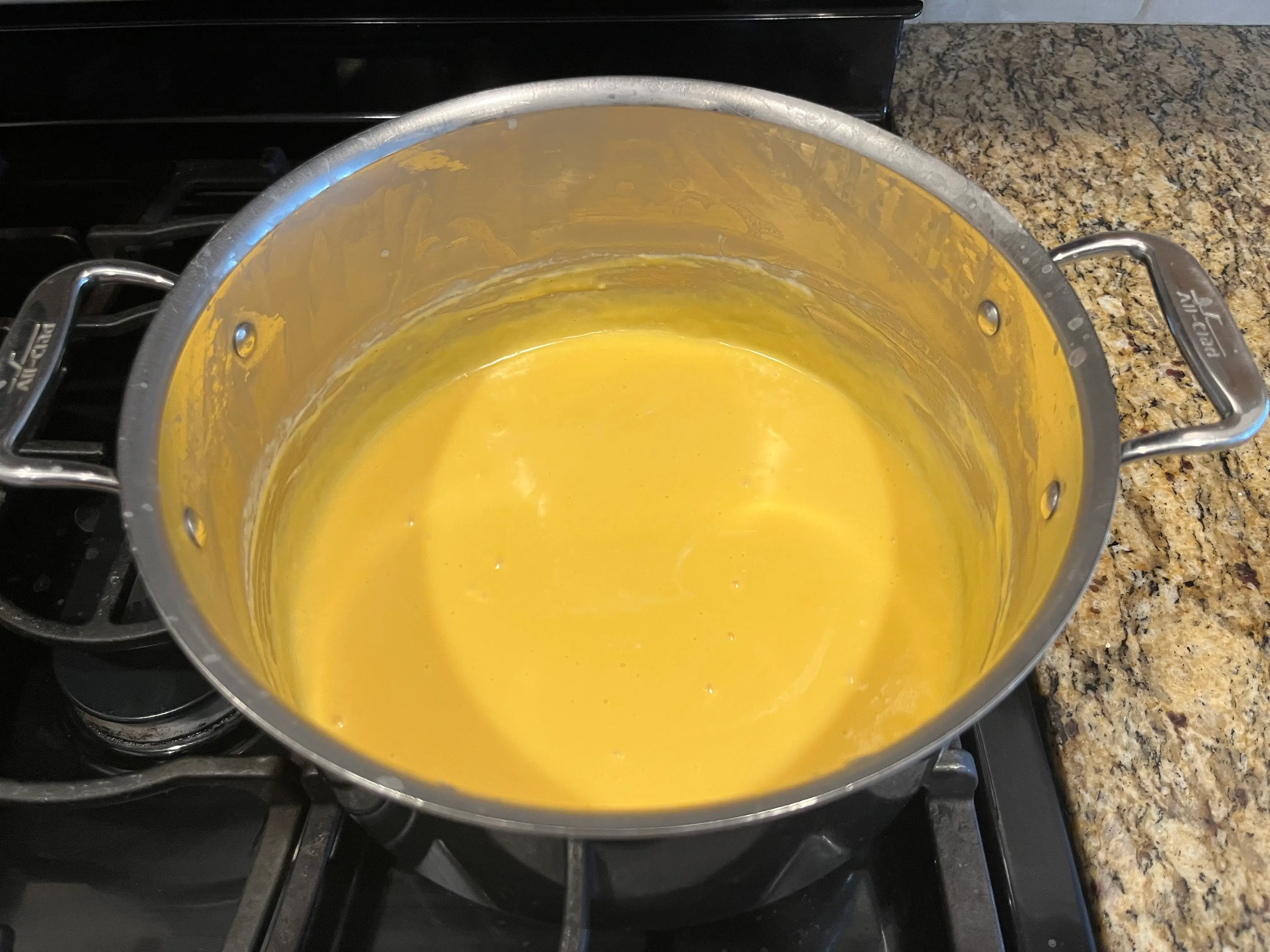 mac and cheese recipe cheese sauce on stove in pot