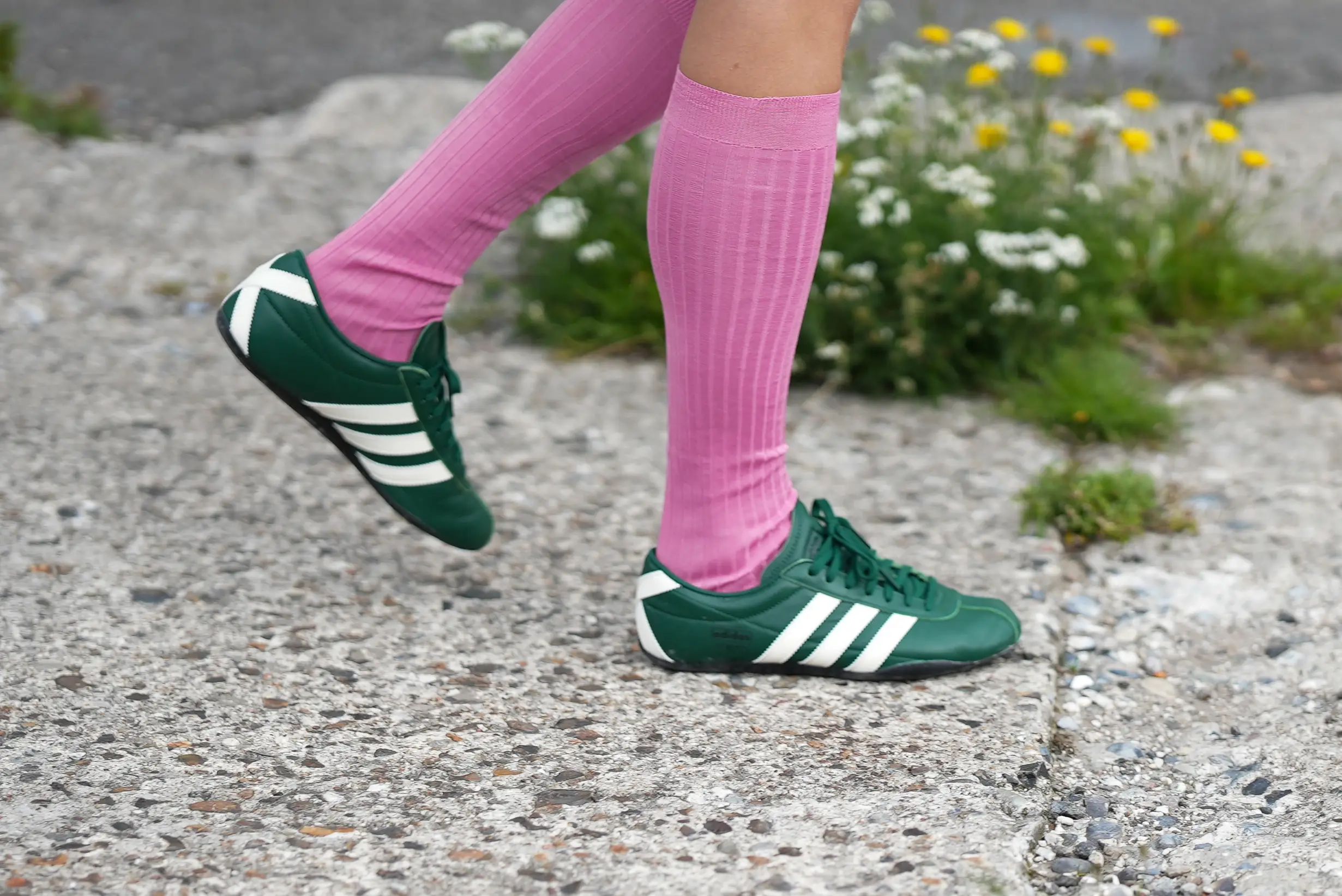 A guest is seen wearing Adidas Originals Tokyo low Sneaker in dark green; pink shiny stockings during Copenhagen Fashion Week day four on August 7, 2025 in Copenhagen, Denmark.