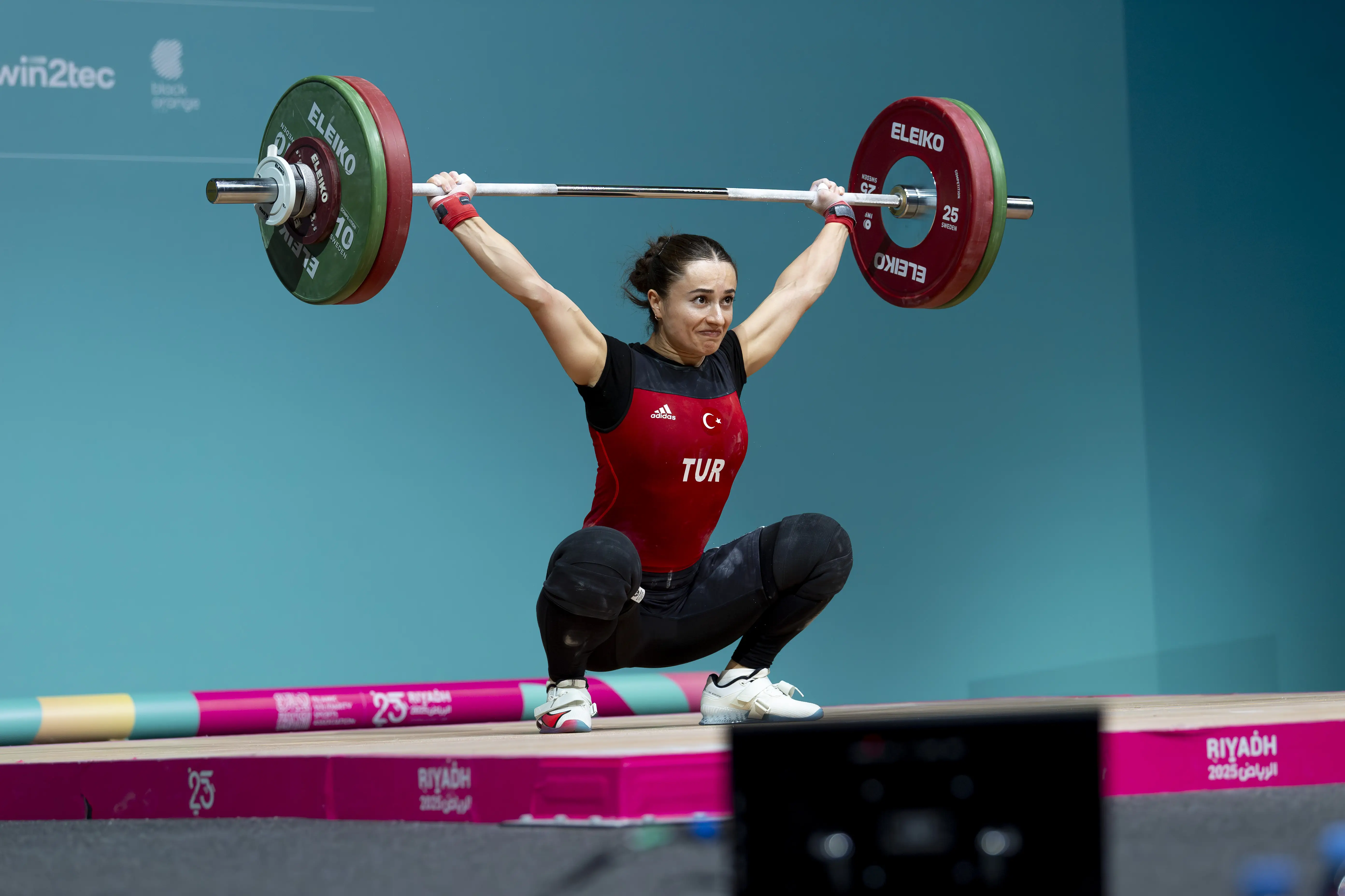 A woman in a deep squat lifting weights