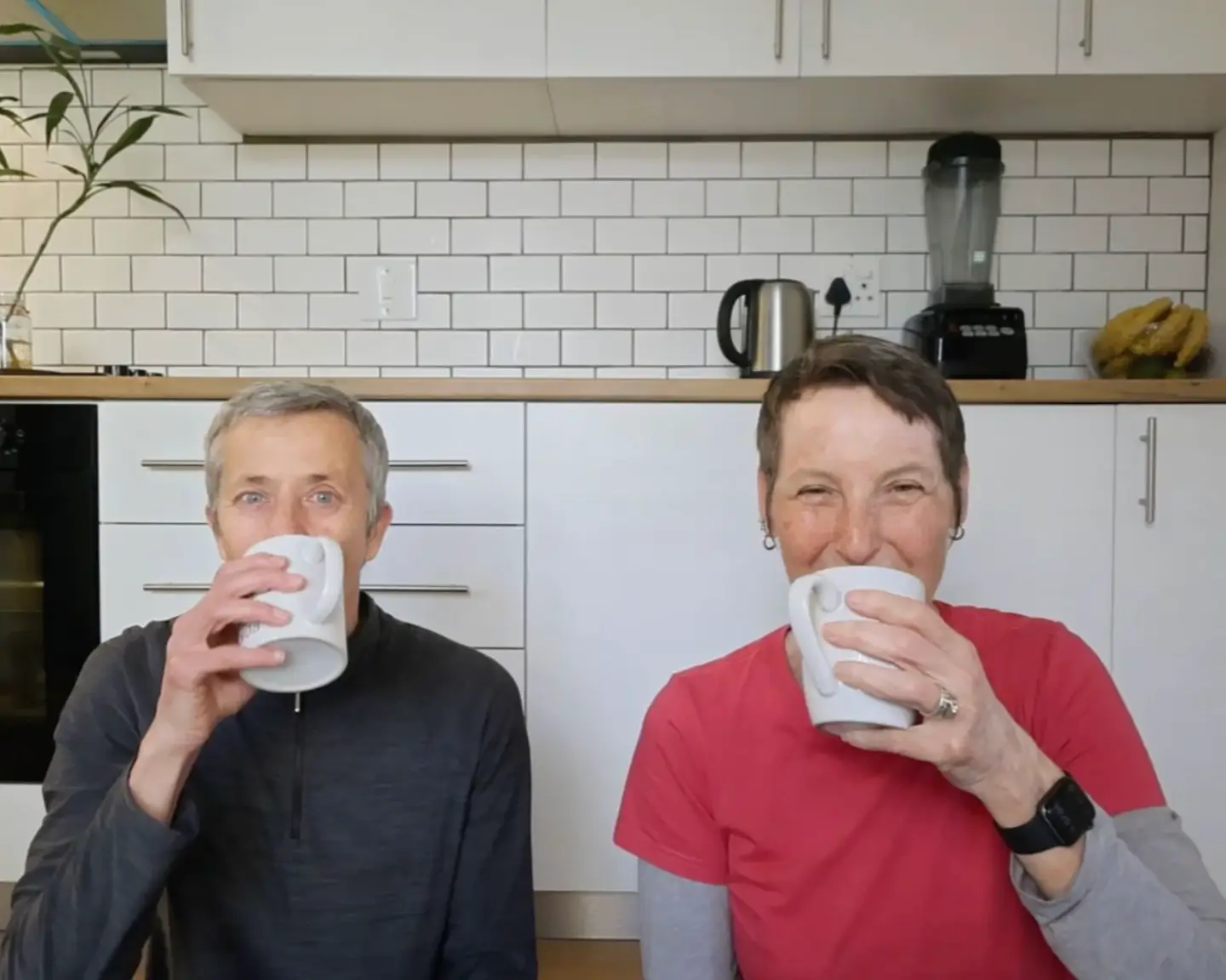 The writer and her wife drinking coffee on the floor of their furniture-free home.