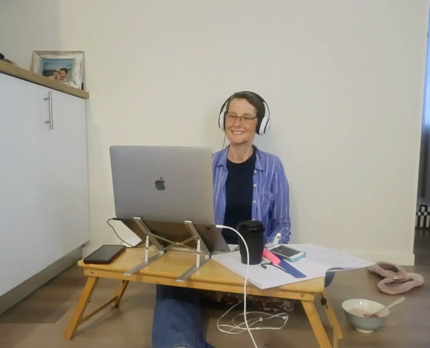 The writer working on her laptop while sitting on the ground.