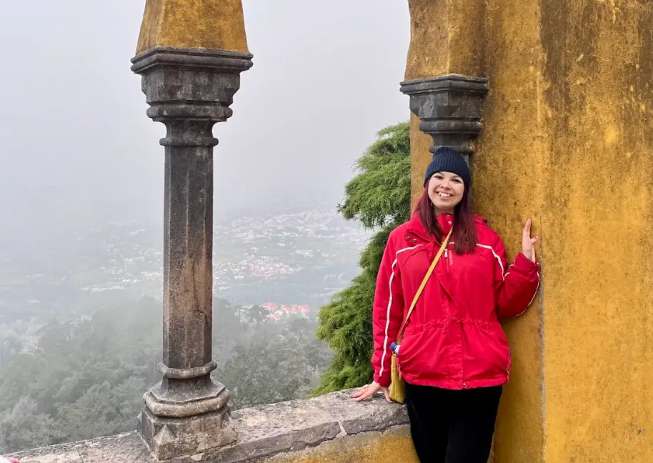 The writer posing in front of a Lisbon landscape.