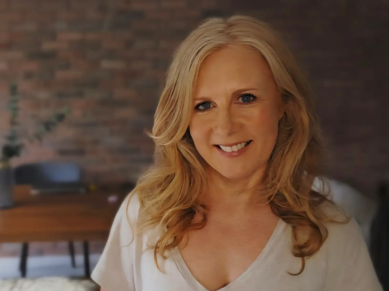 Tracy Gunn posing in front of a brick wall.