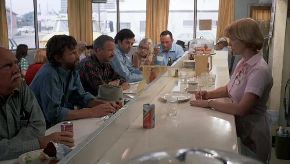 Laura Dern as a child sitting in the diner