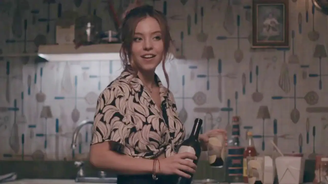 Sydney Sweeney holding a bottle of wine