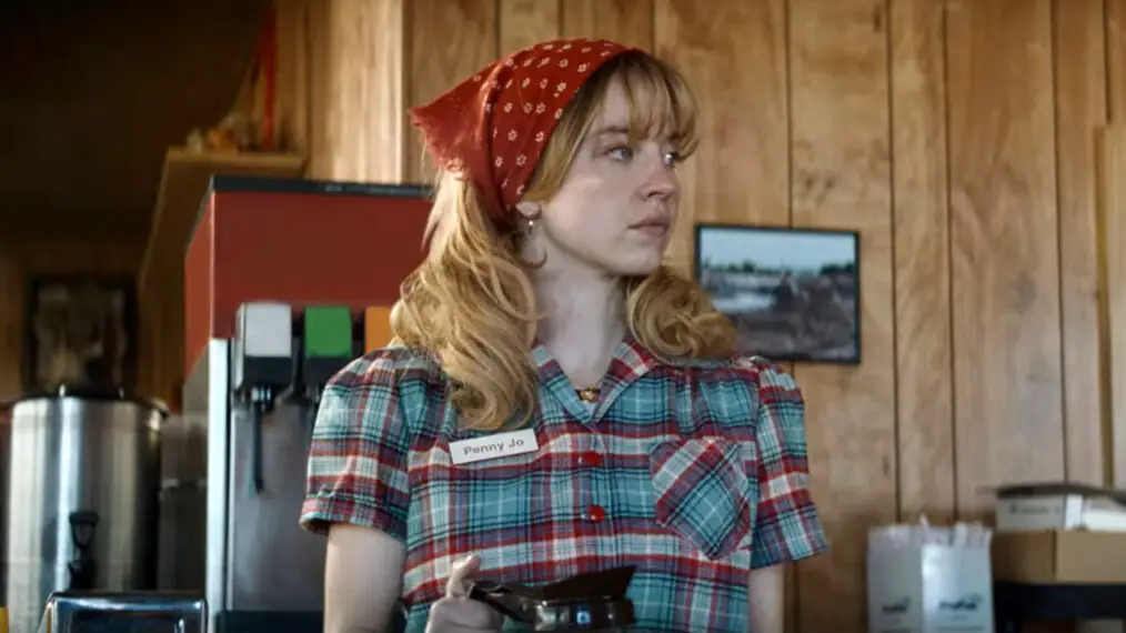 Sydney Sweeney in a red headband holding a coffee