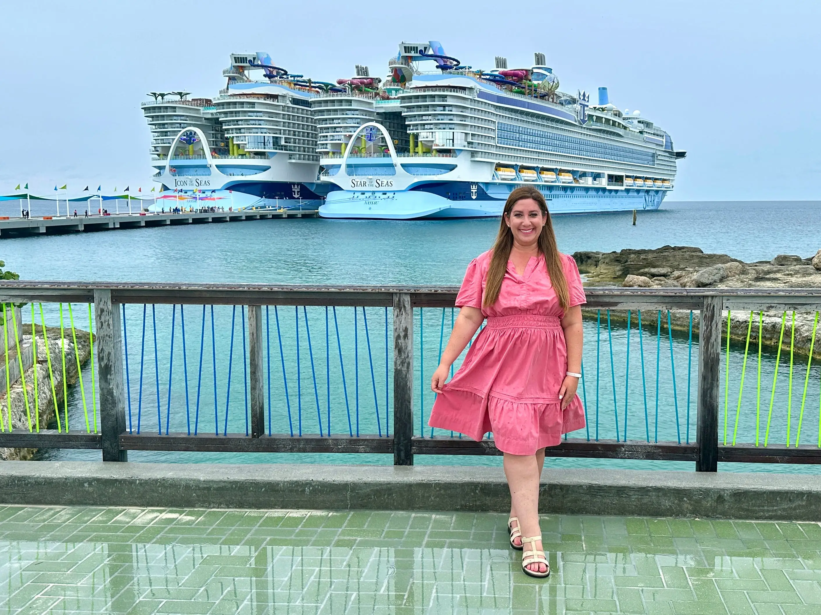 Author Jill Schildhouse smling in front of two cruise ships in CocoCay