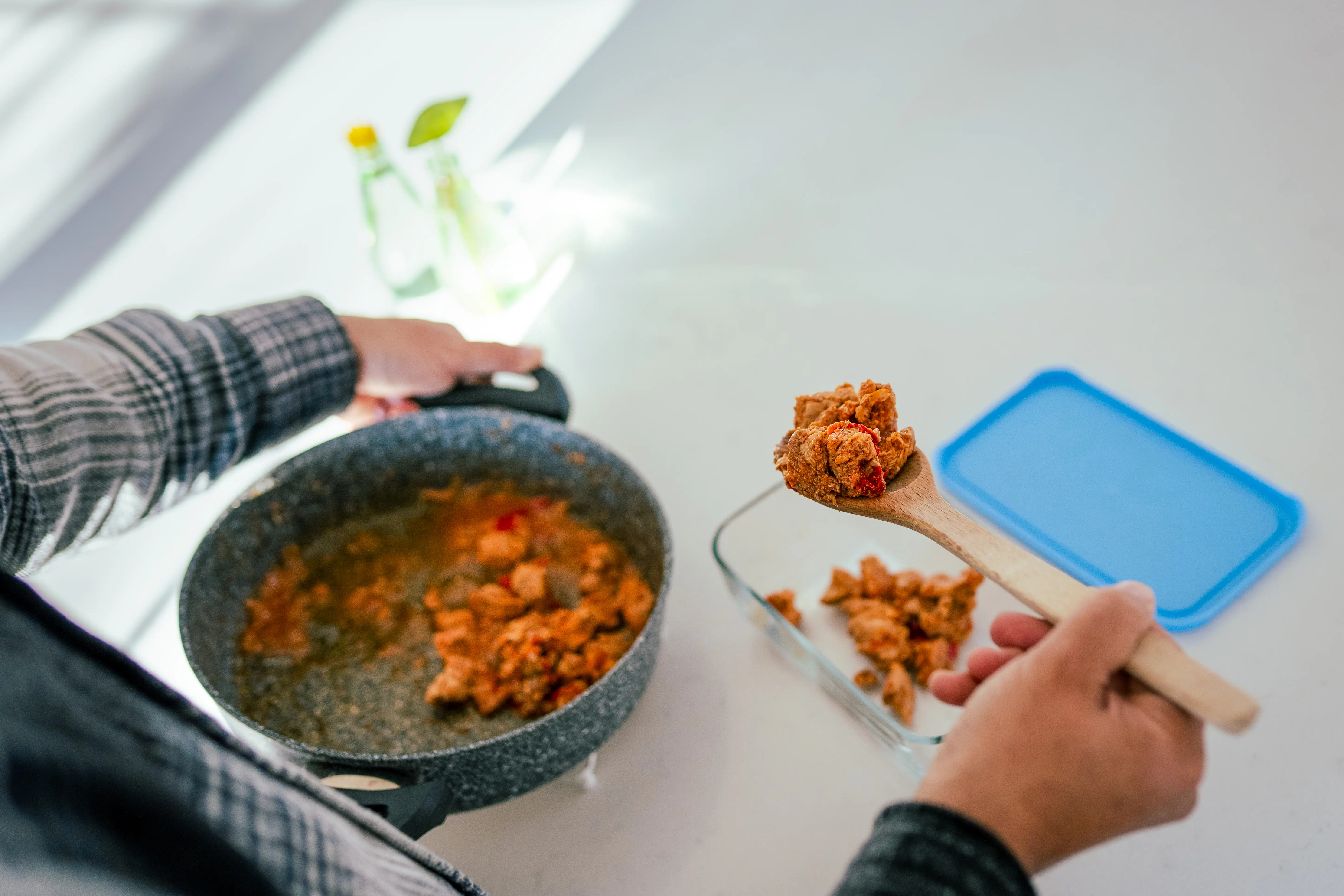 A man fills a Tupperware with leftovers.