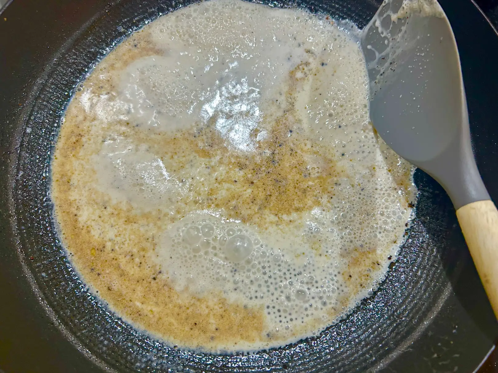 Melting peppercorns into butter to create a cacio e pepe sauce.