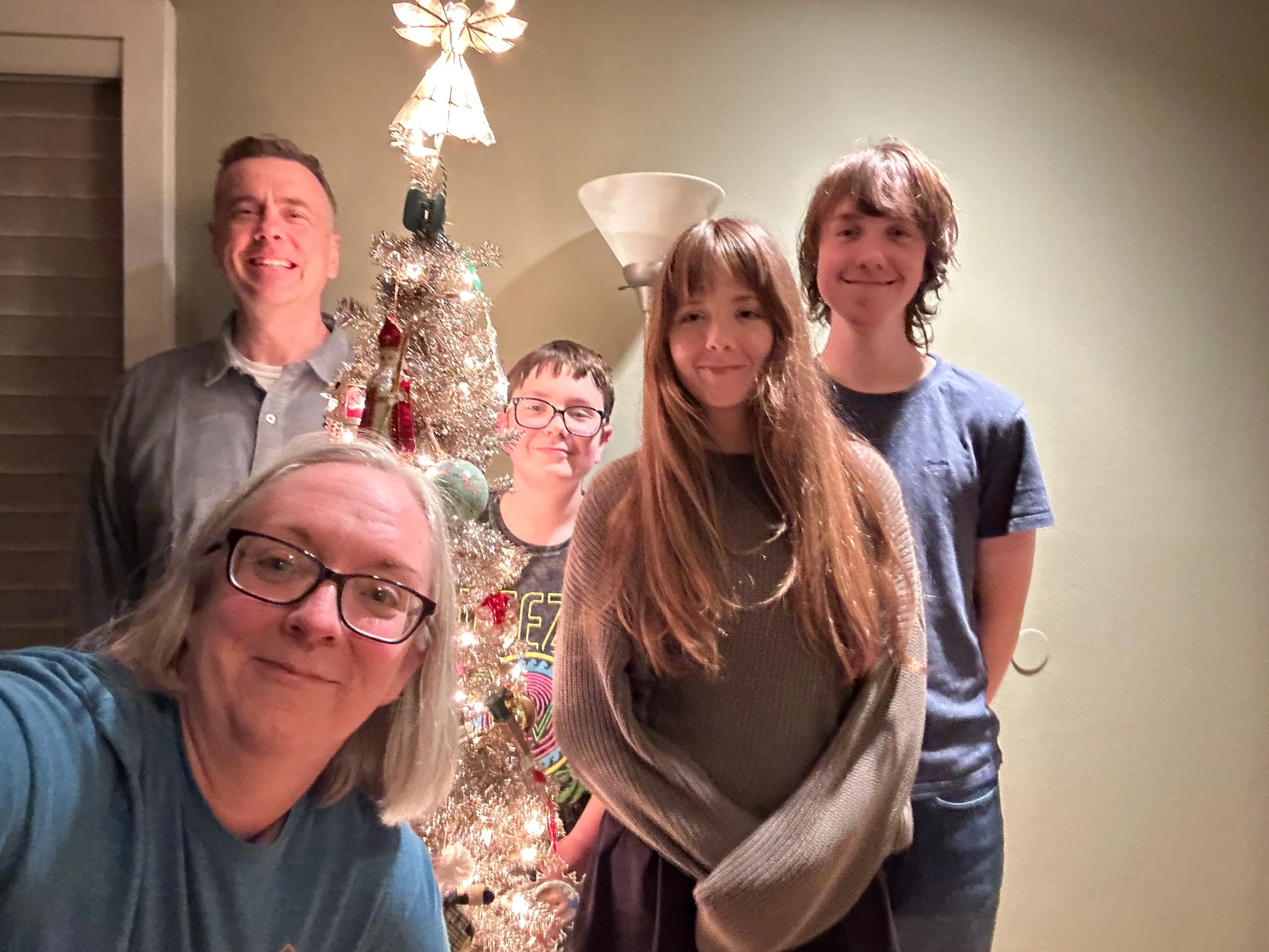 The author poses next to a Christmas tree with her husband and their three children.