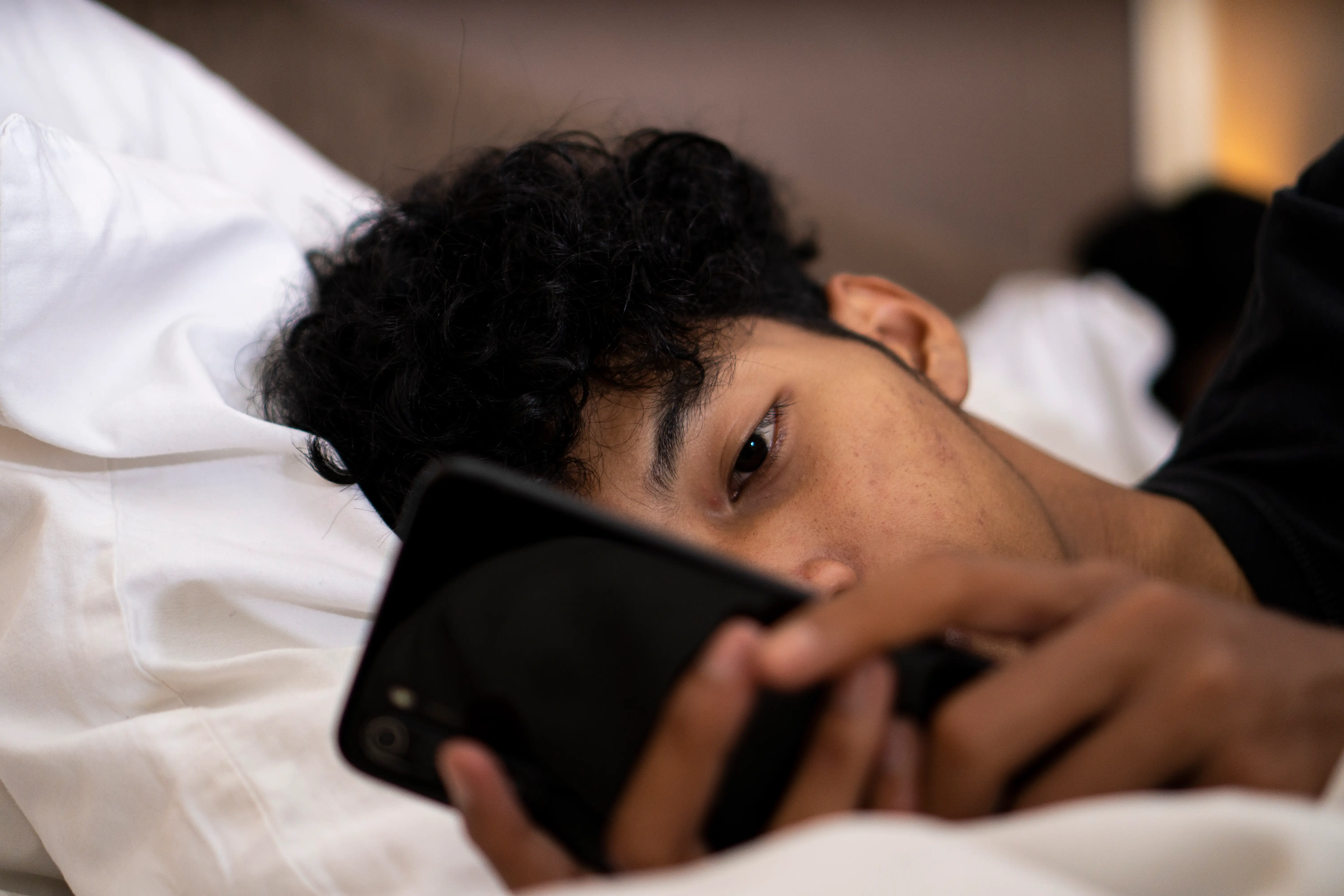 Man in bed with phone
