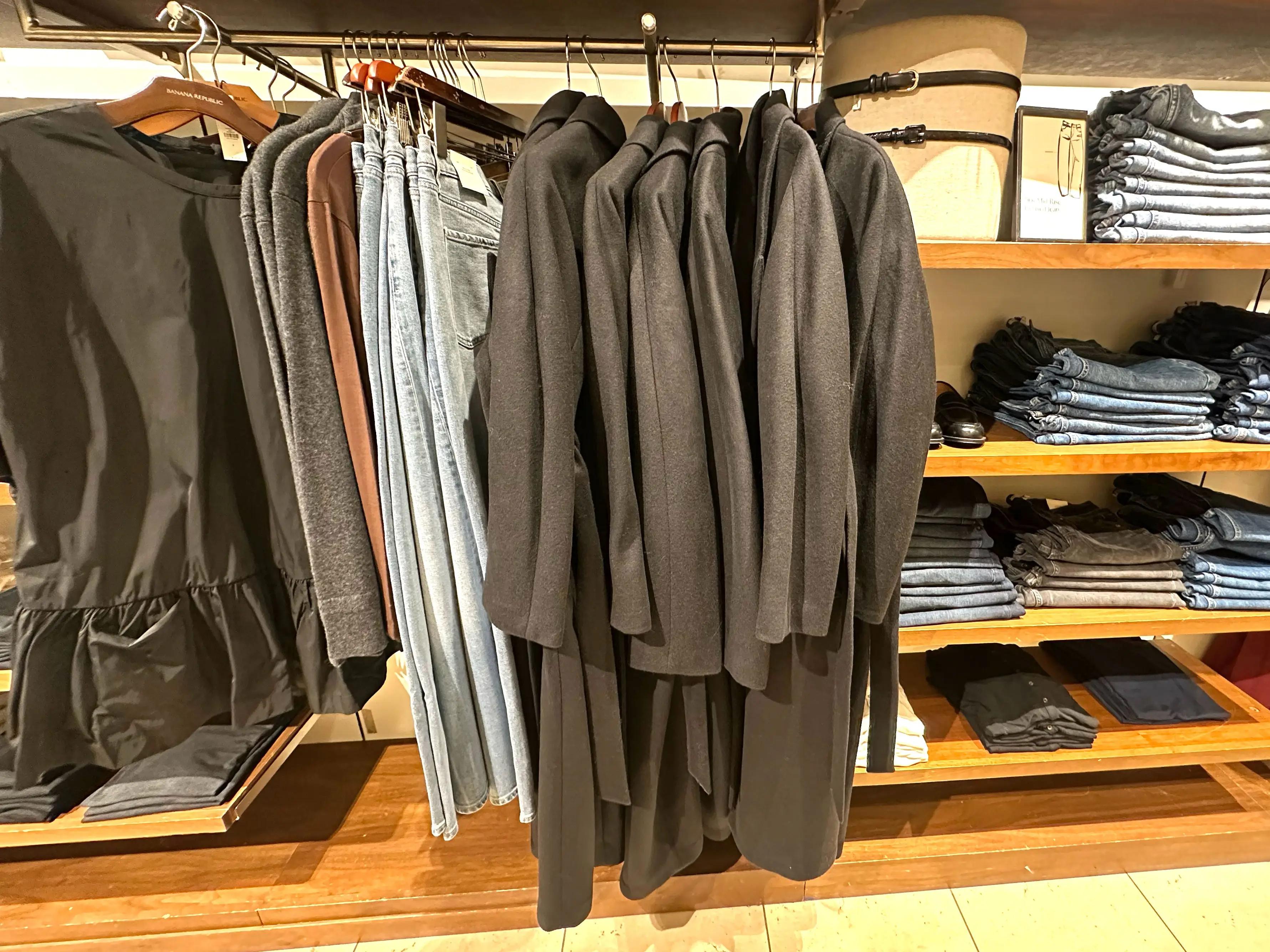 Coats, jeans, and shirts hanging at Banana Republic.