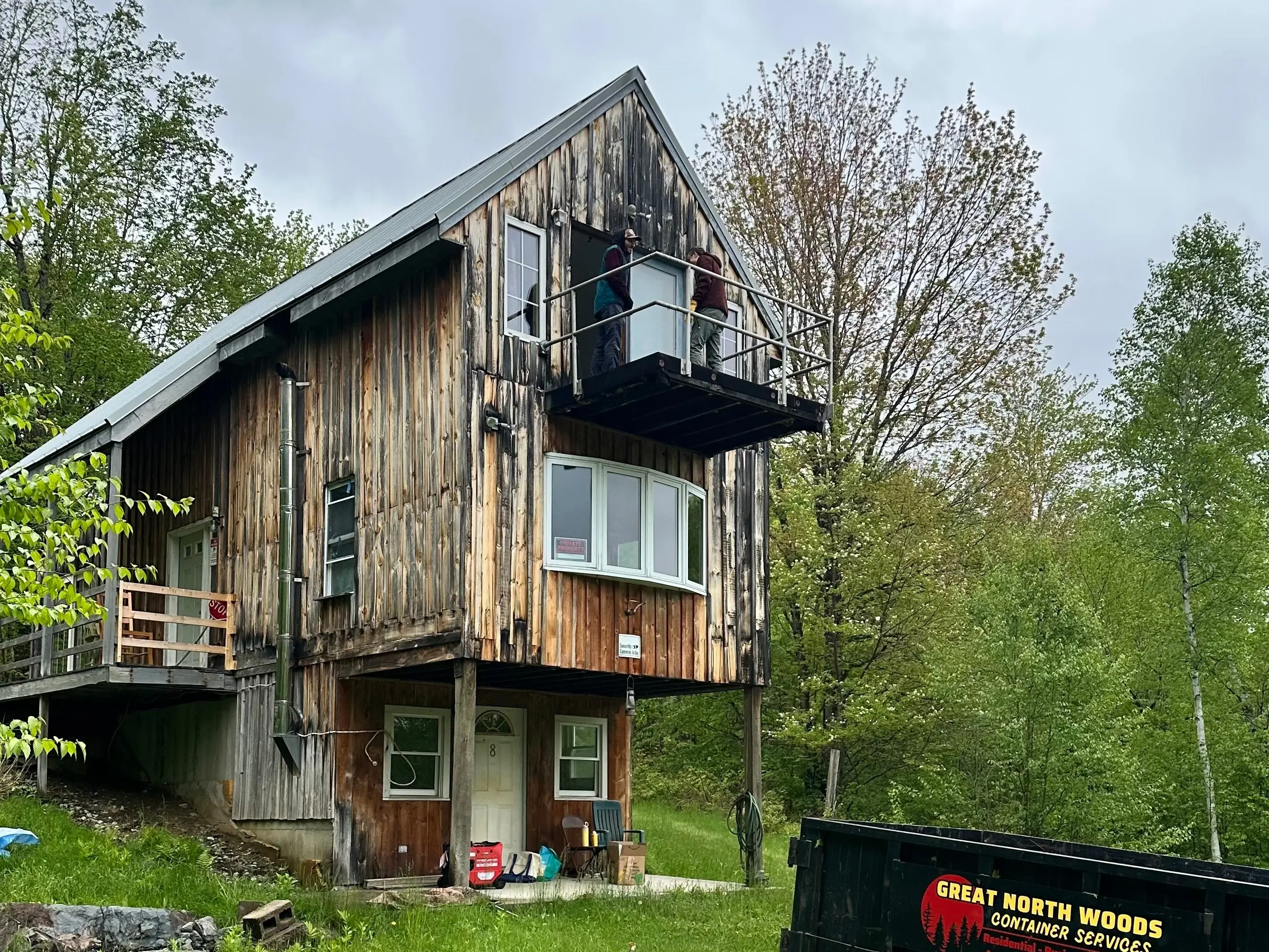 A wide shot of the house with a large dumpster in front of it.