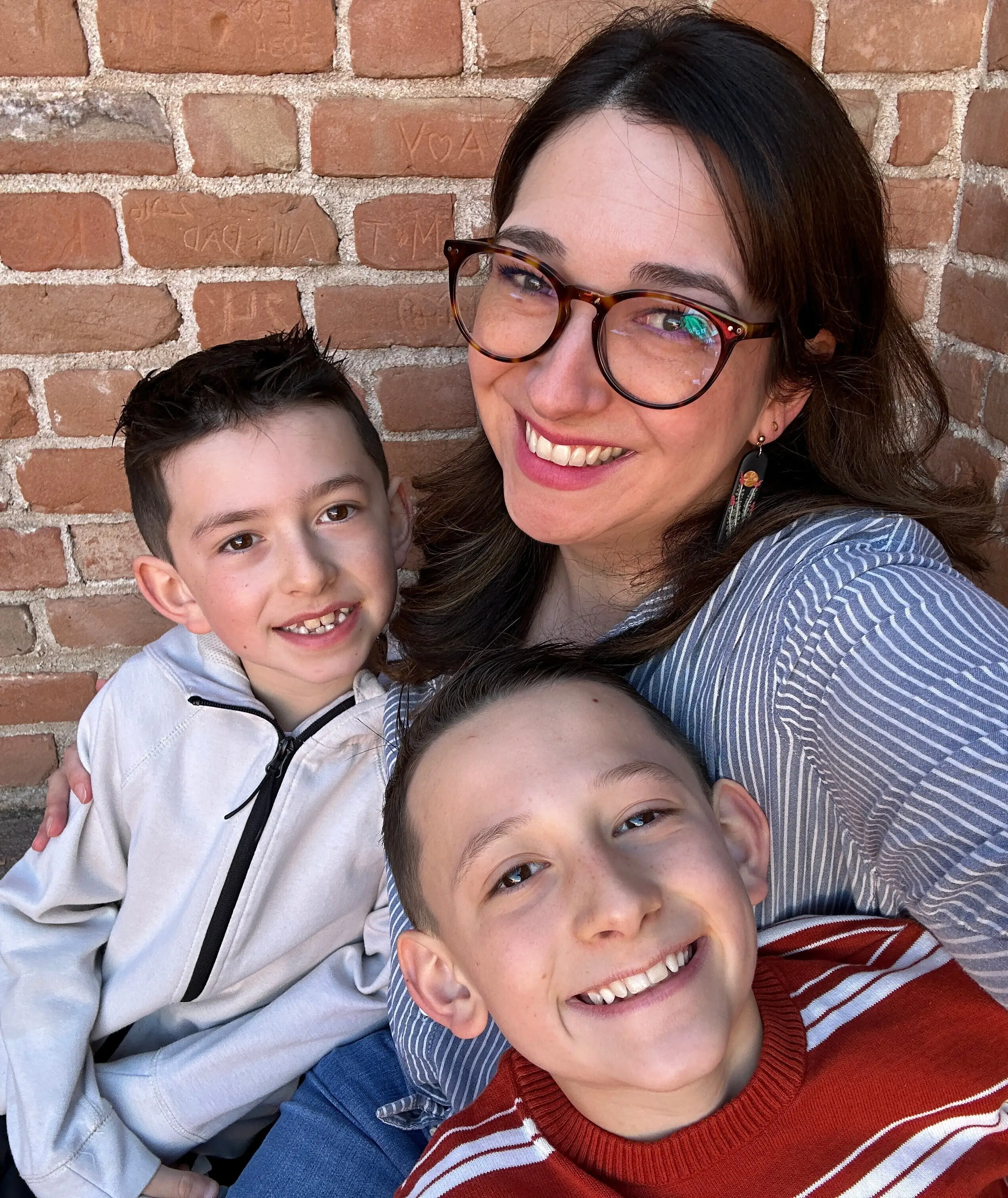 The author and her two sons smile in front of a brick wall.