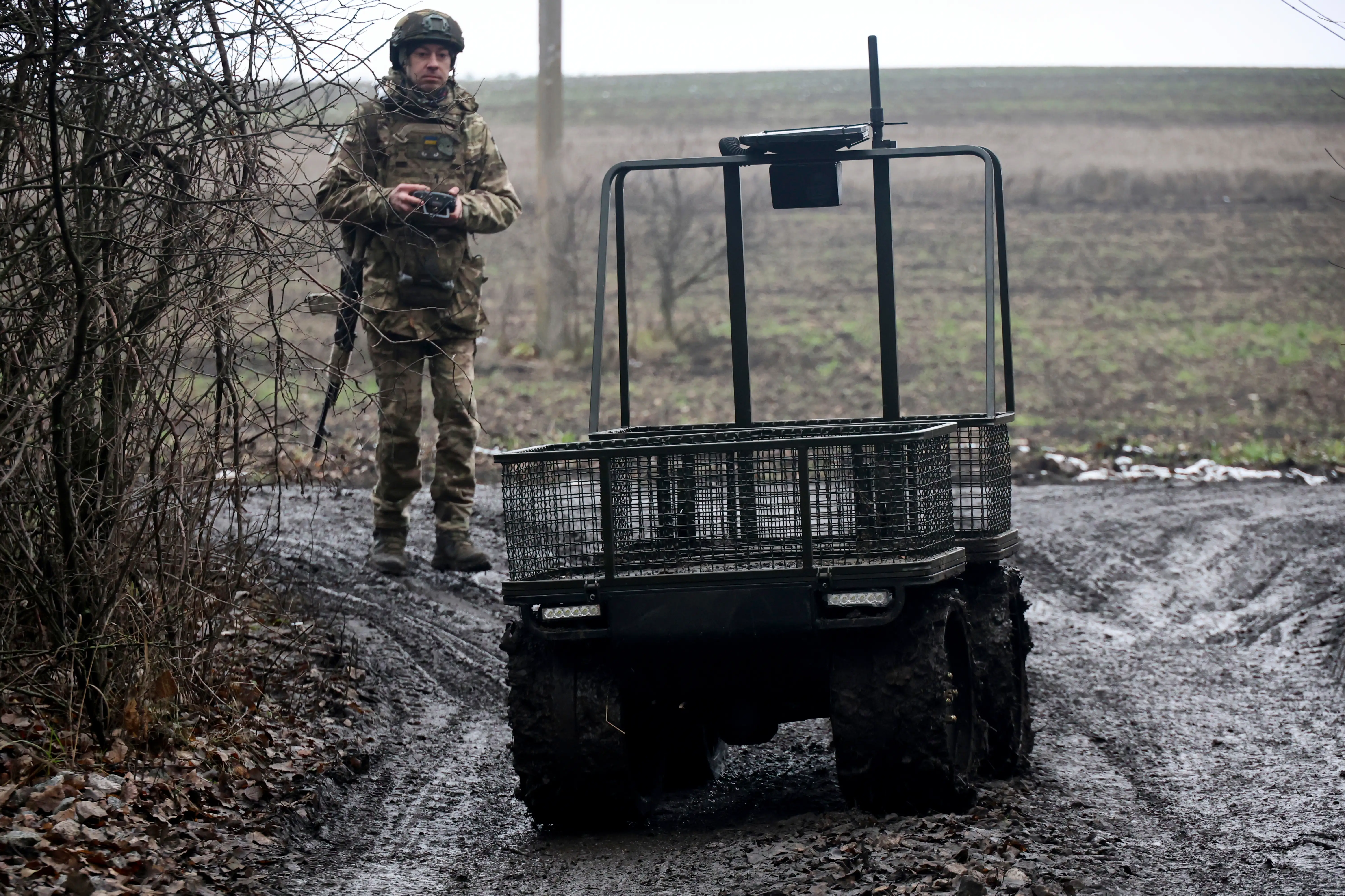 A Ukrainian soldier remotely pilots an uncrewed ground vehicle.