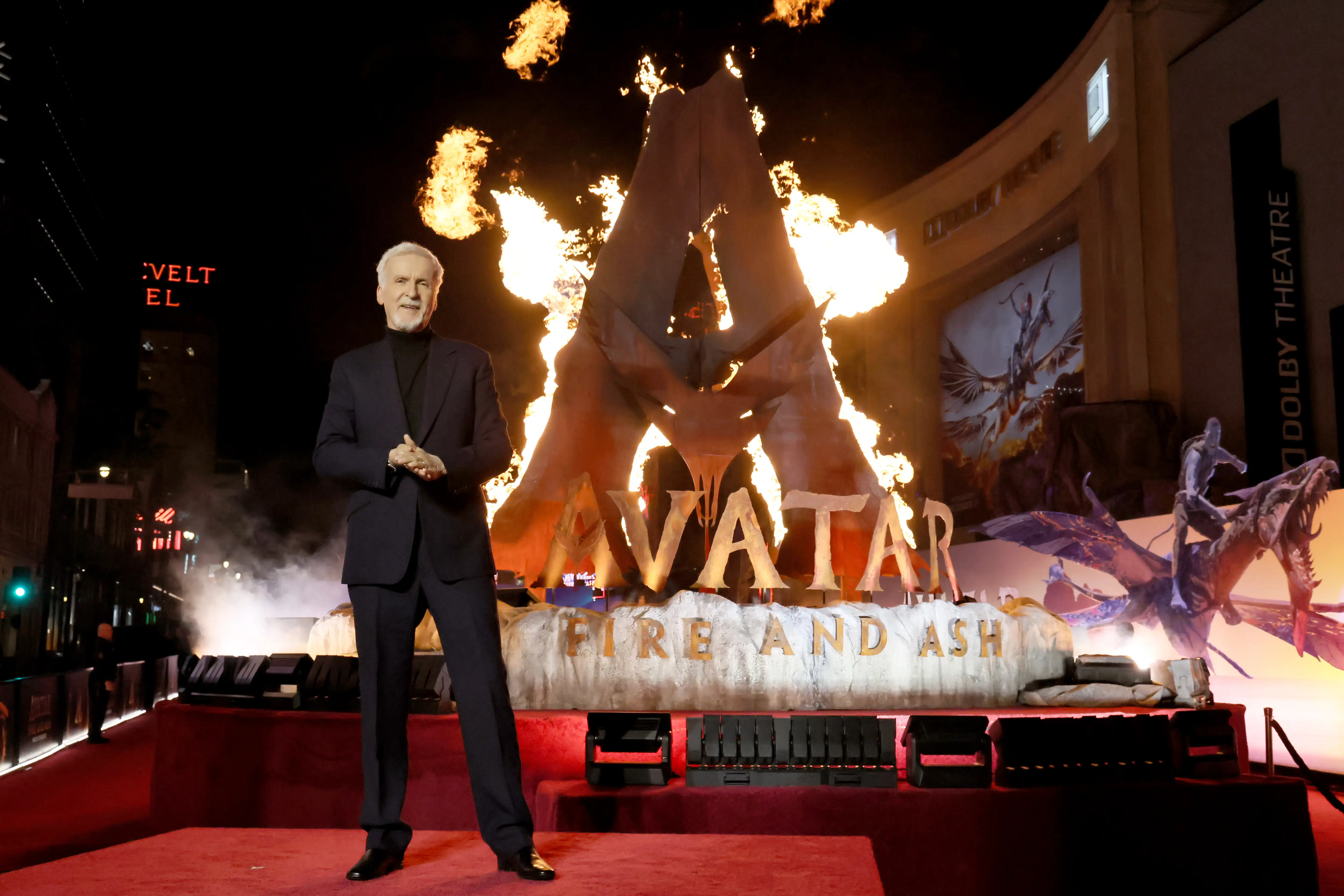 James Cameron standing in front of a flaming Avatar sign