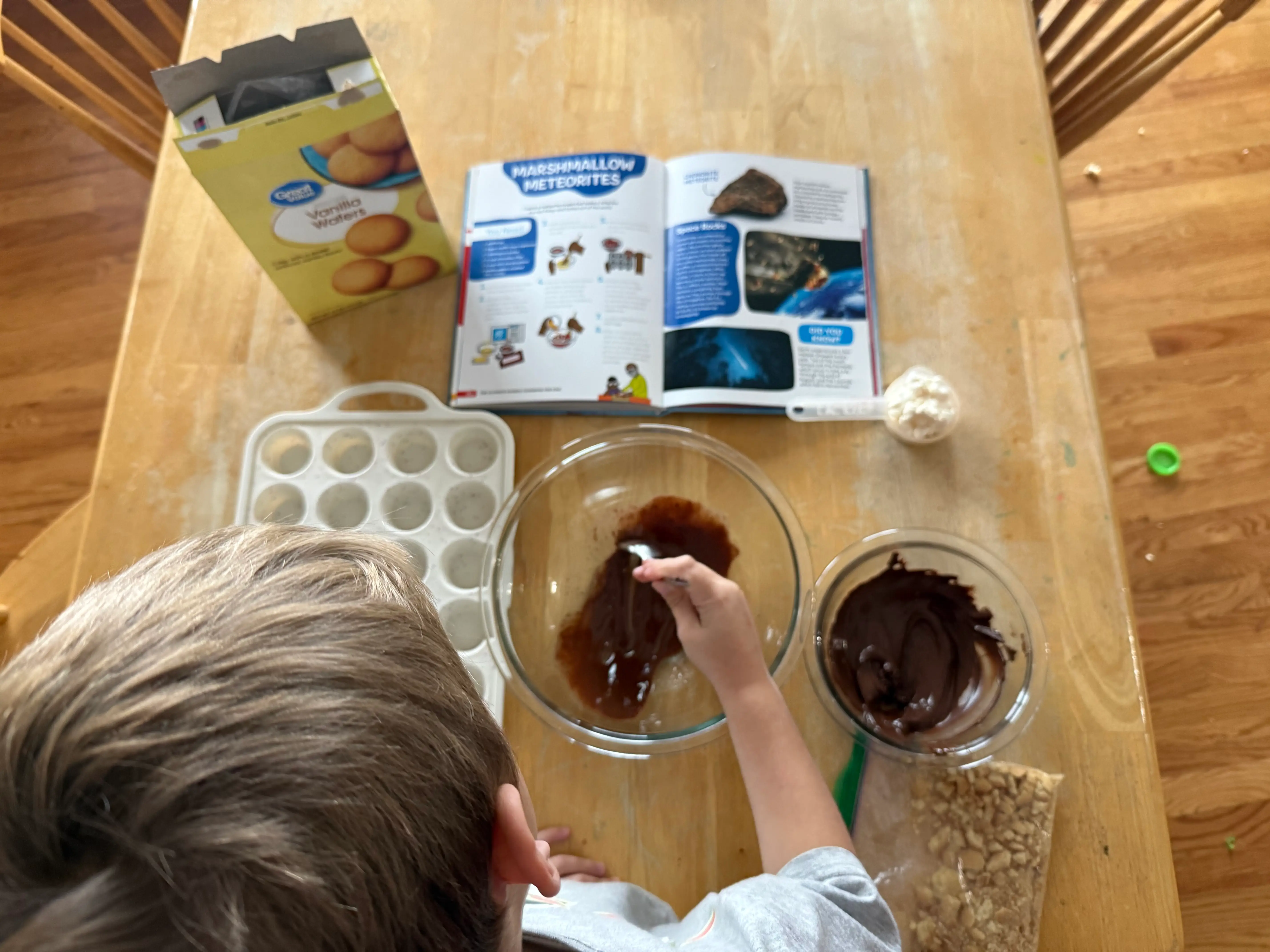 The author's son follows a recipe from a STEM-based cookbook for kids.