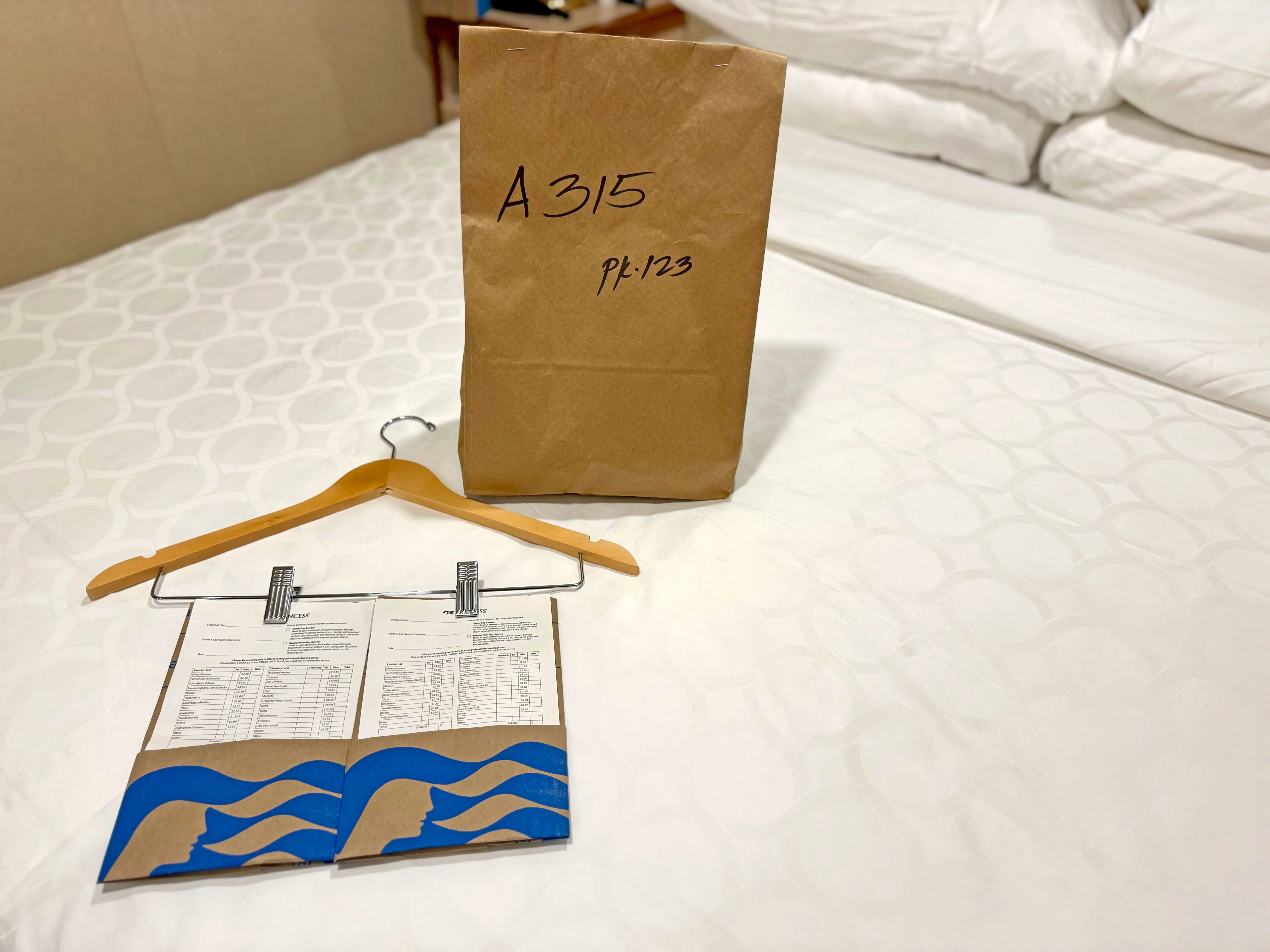 Slips of paper and a paper bag on a bed.