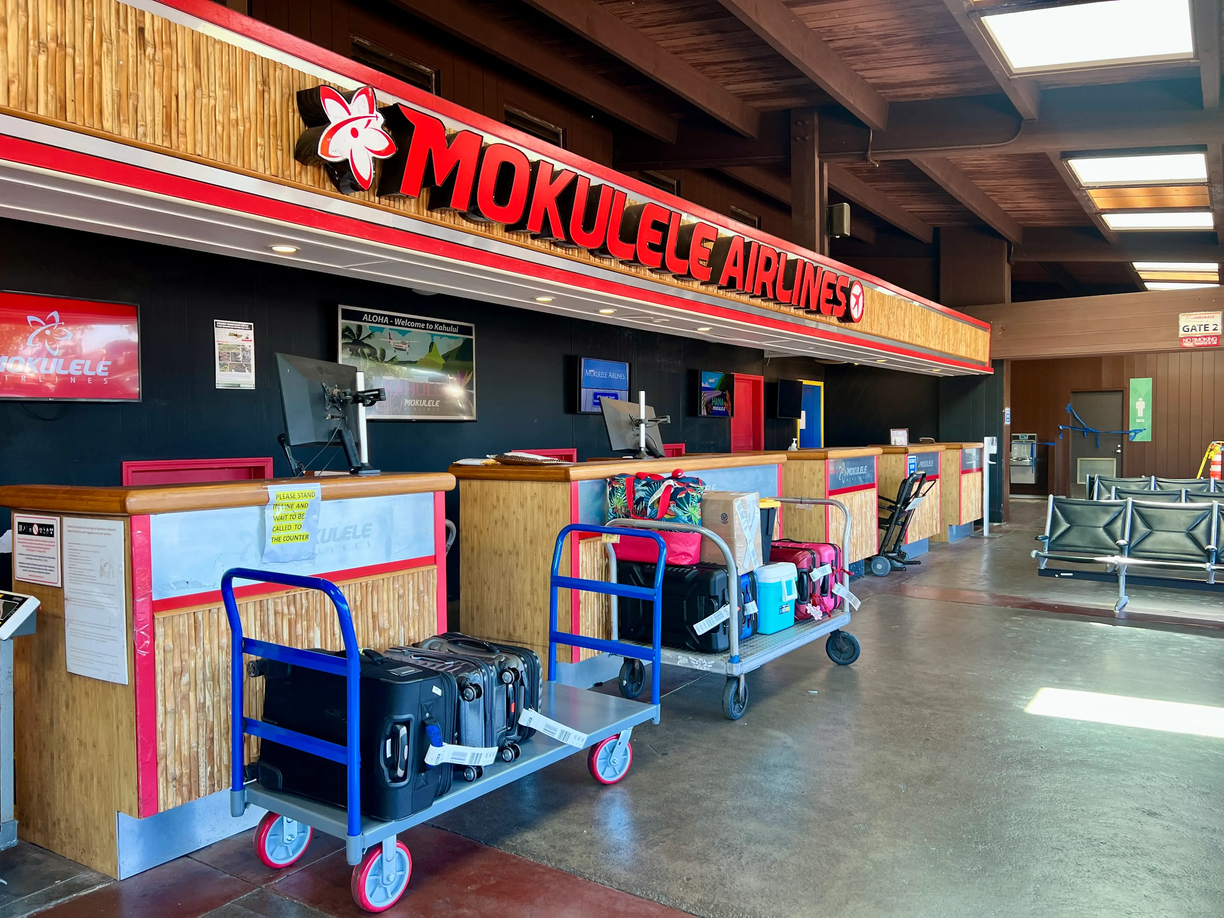 Mokulele Airlines sign with luggage carts in front
