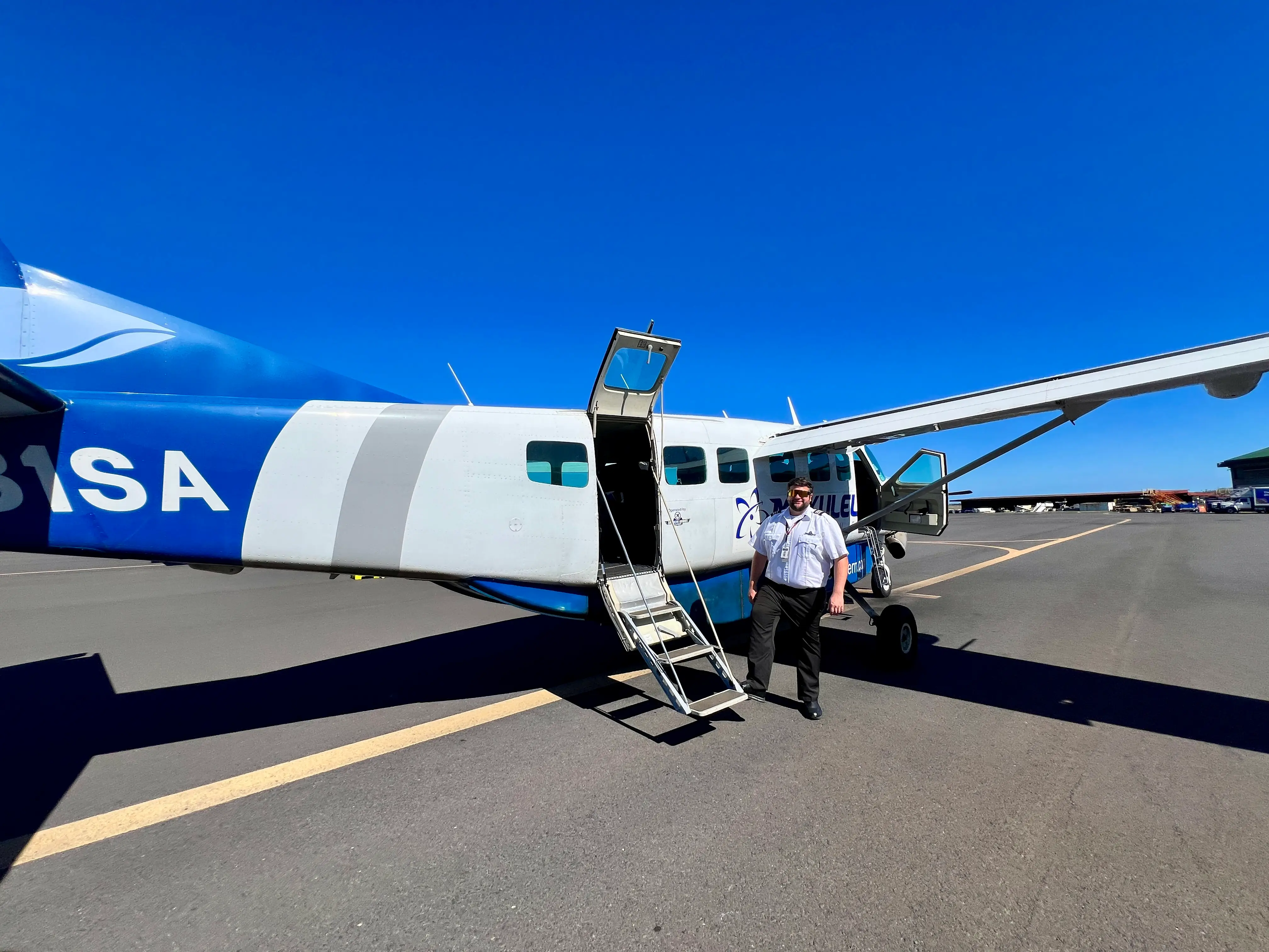 Man standing outside of smalll plane on tarmac