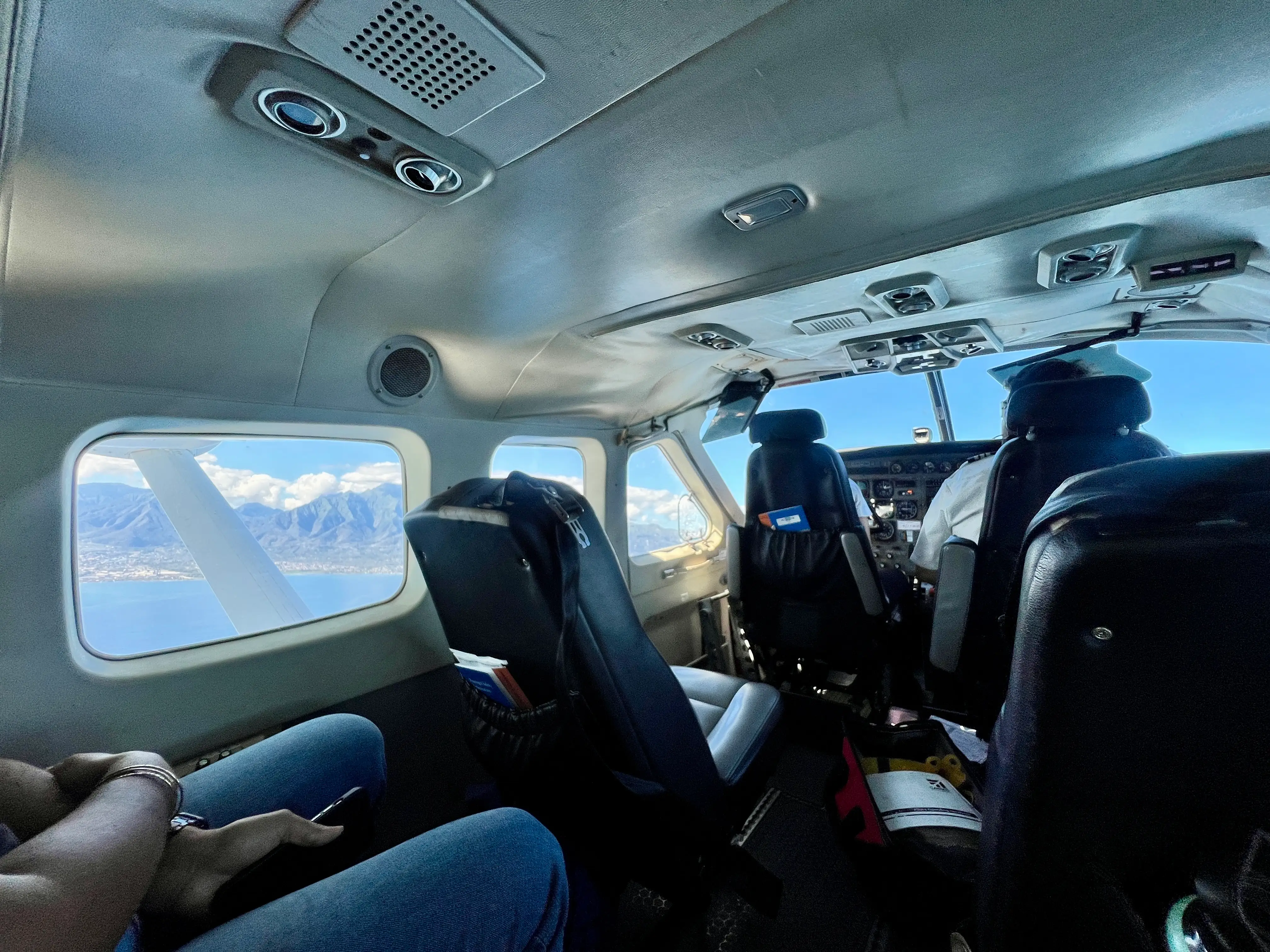Interior of small plane with leather seats, view of mountains outside window