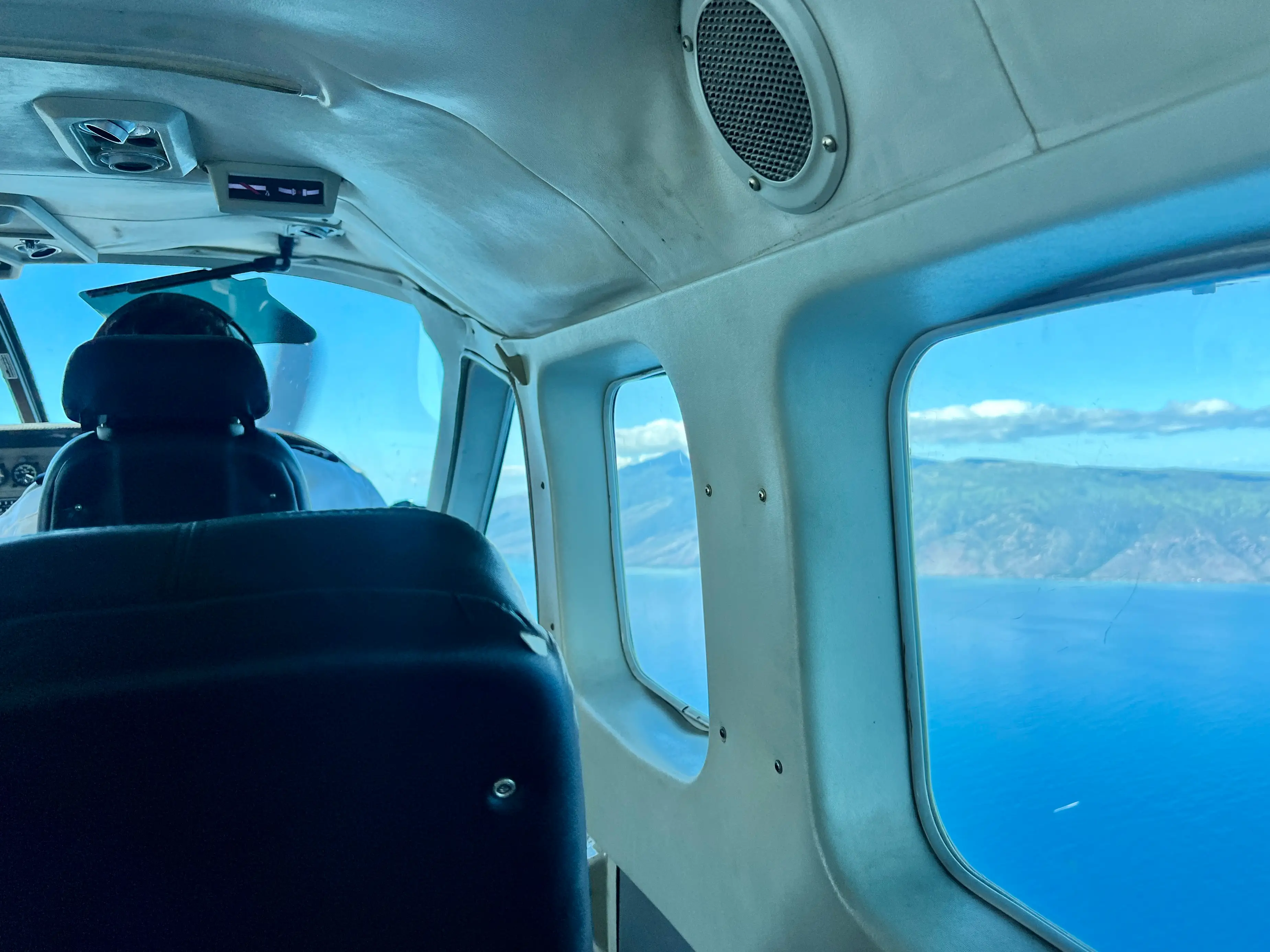 View outside of plane window of water, mountains