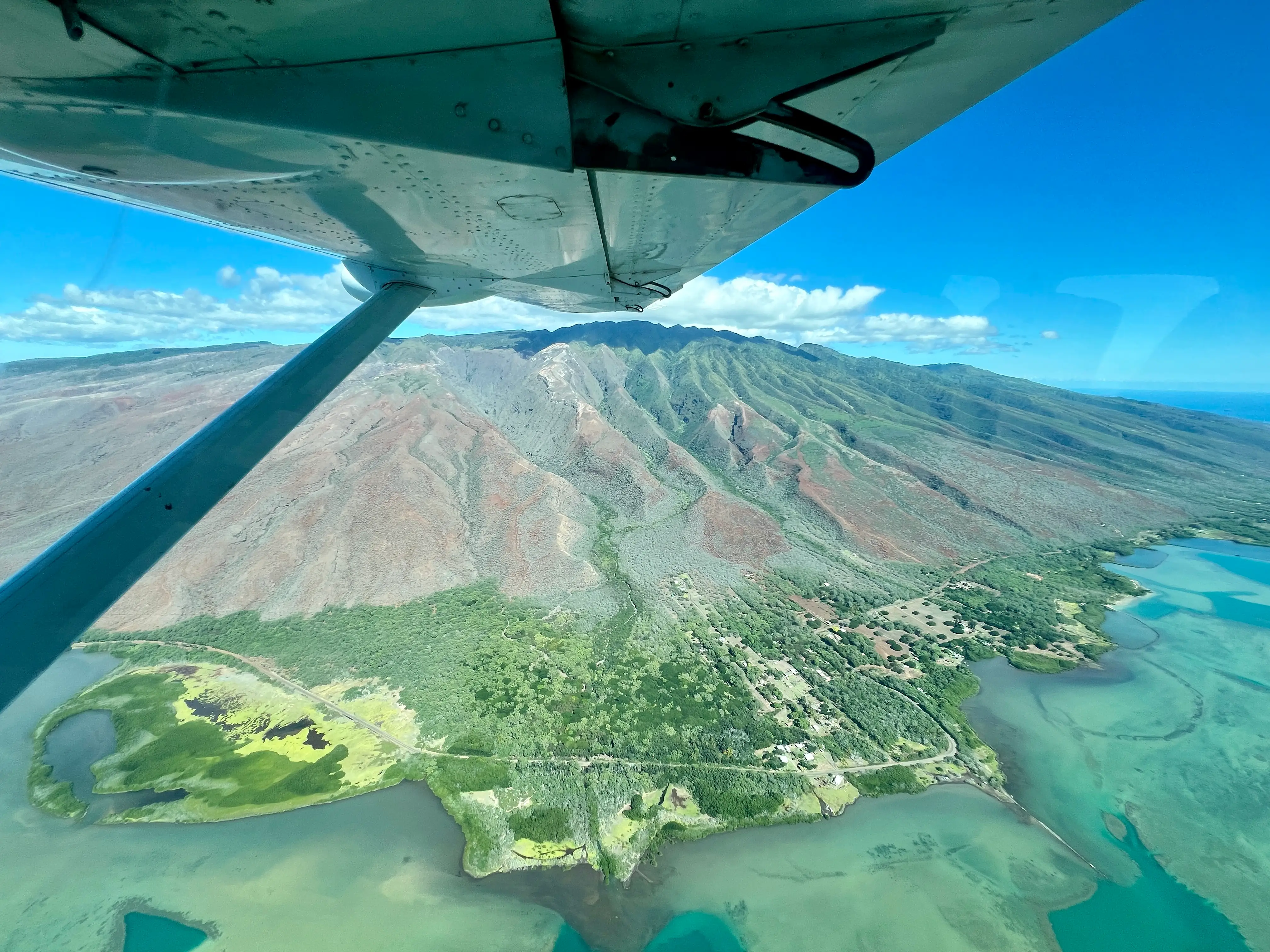 View of mountains, greenery from plane window