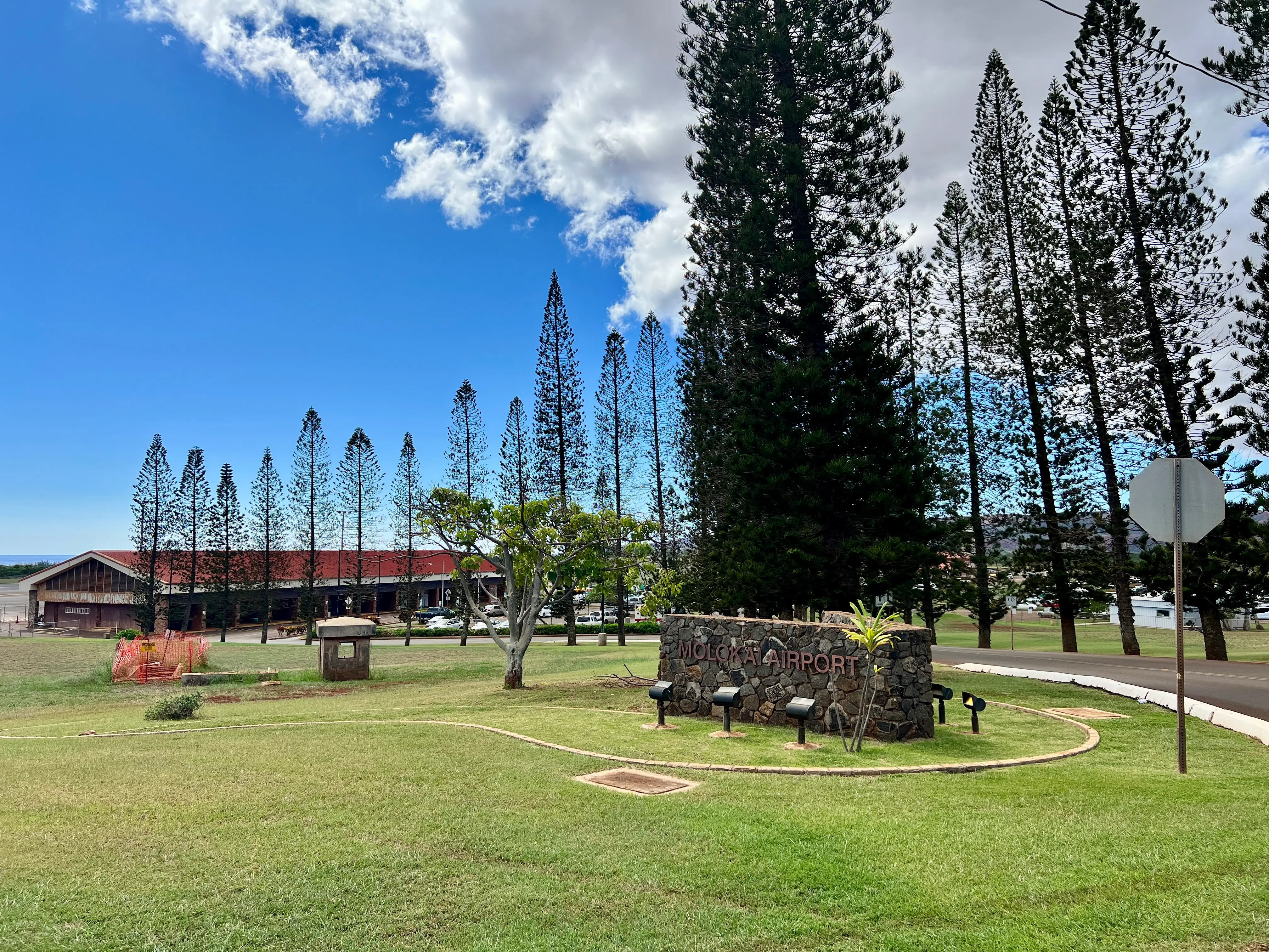 Molokai Airport exterior, stone sign and trees