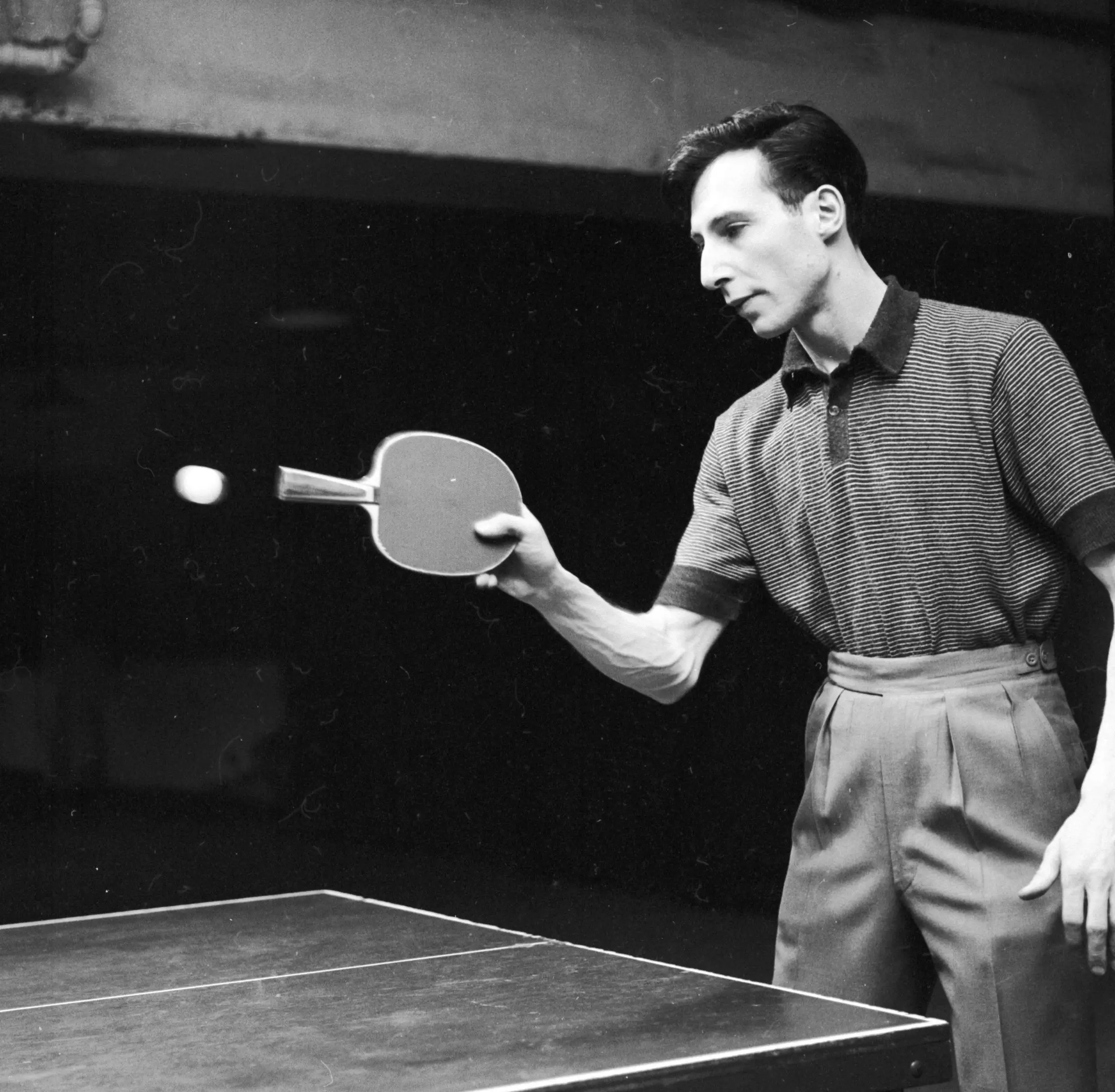 Marty Reisman doing a trick show with handle of paddle hitting the ping pong ball