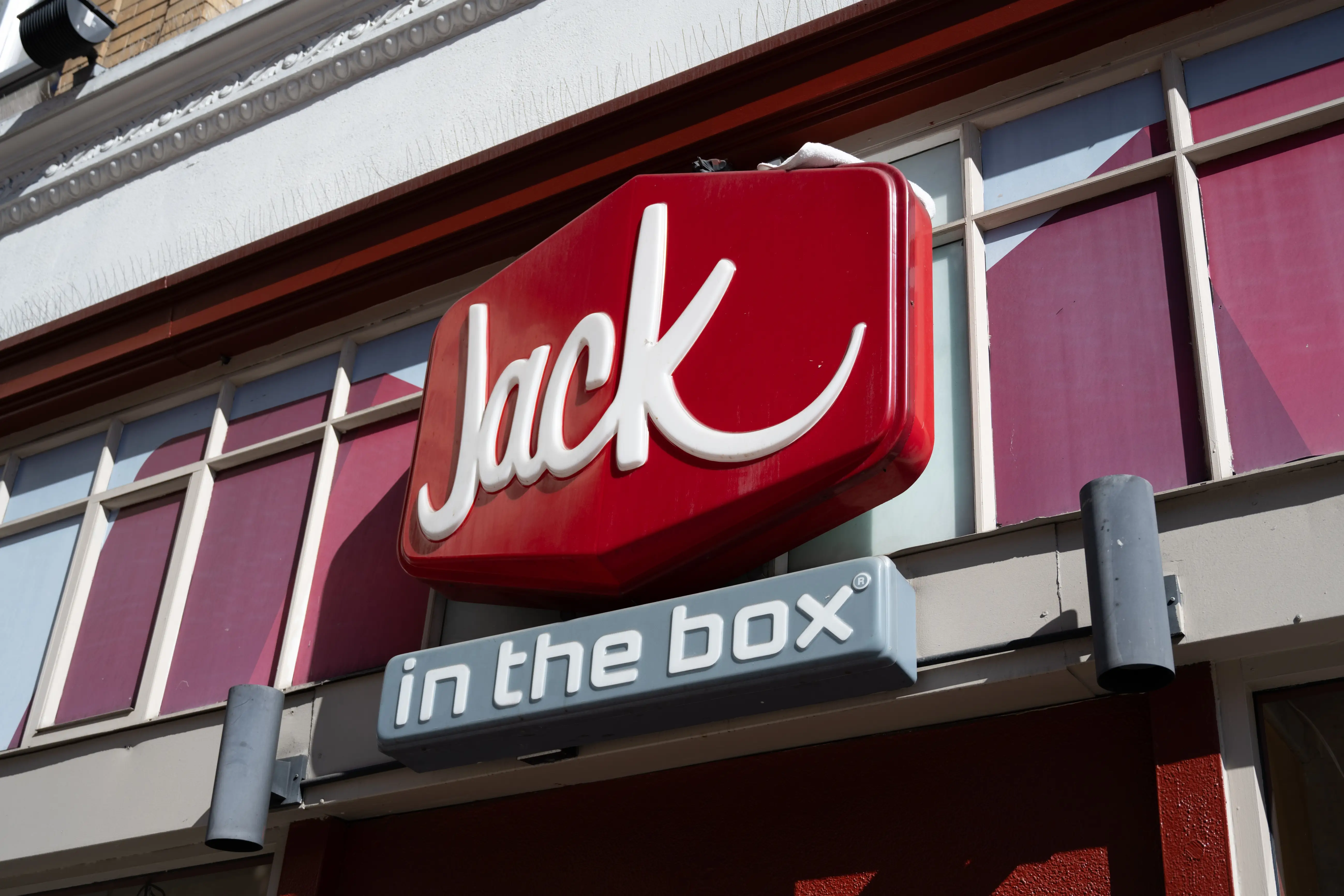 A Jack in the Box logo appears outside a restaurant location.