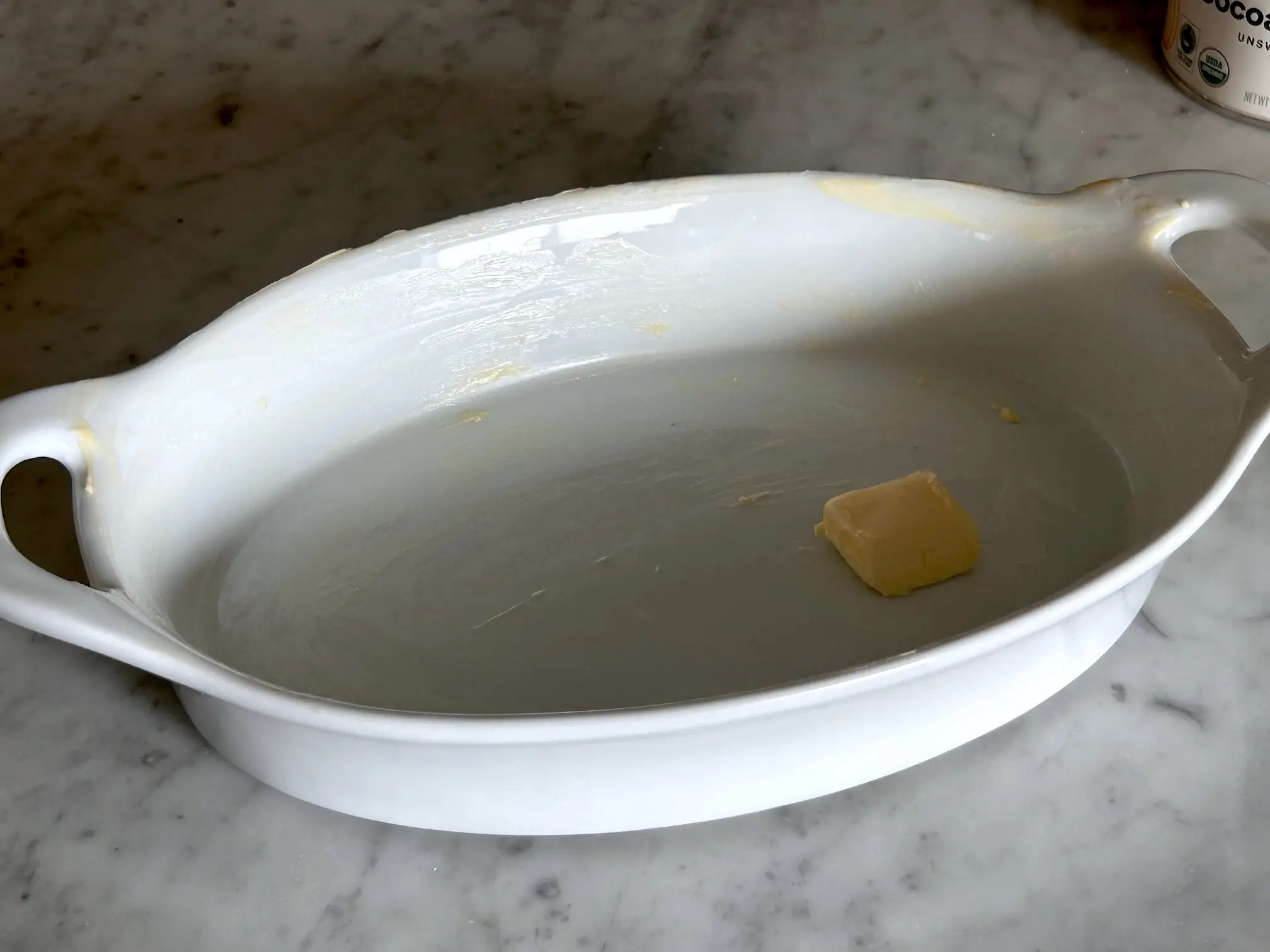 Buttering the baking dish for Ina Garten's brownie pudding