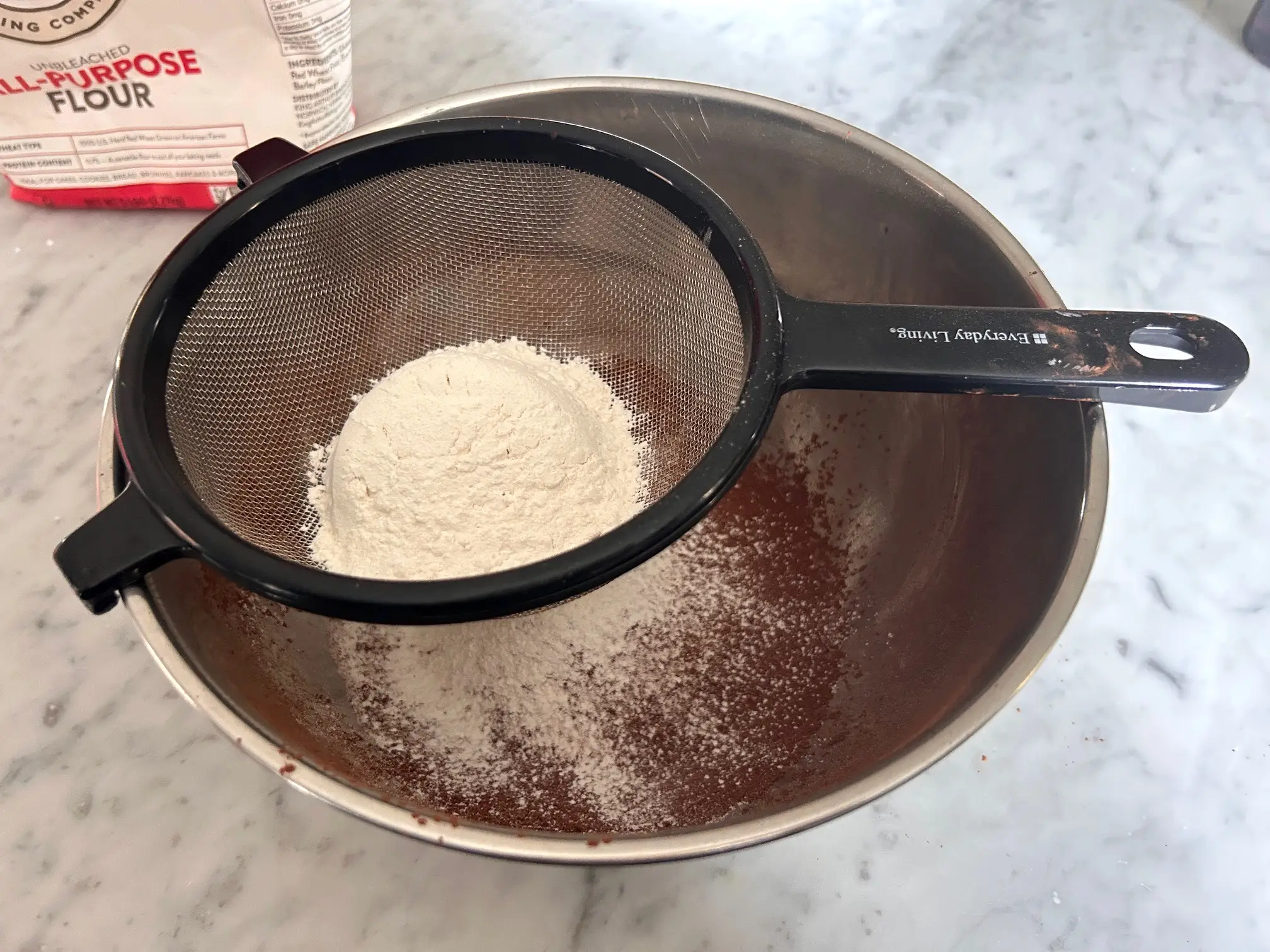 Sifting flour and cocoa for Ina Garten's brownie pudding