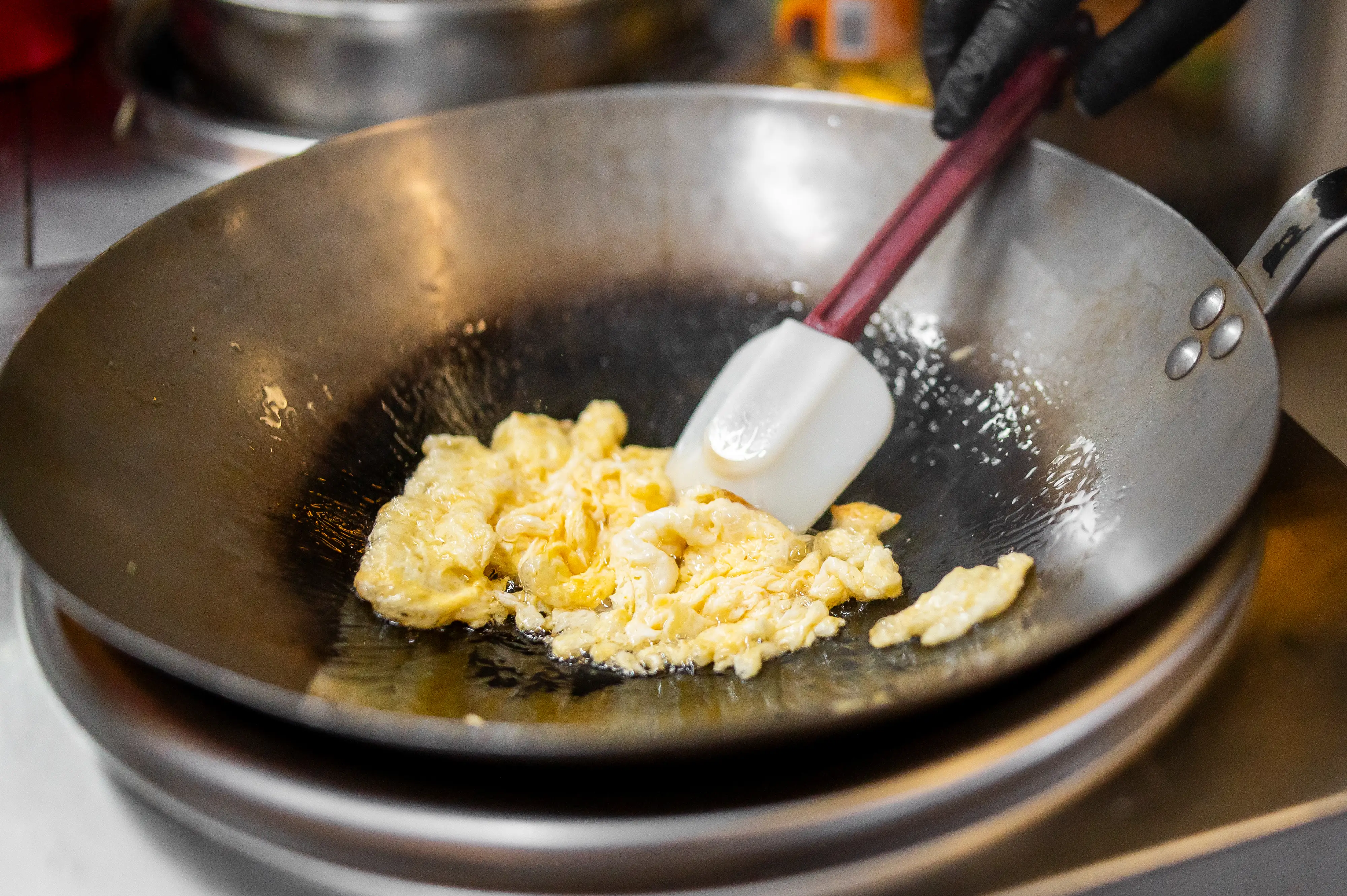 Eggs in pan being pushed by spatula