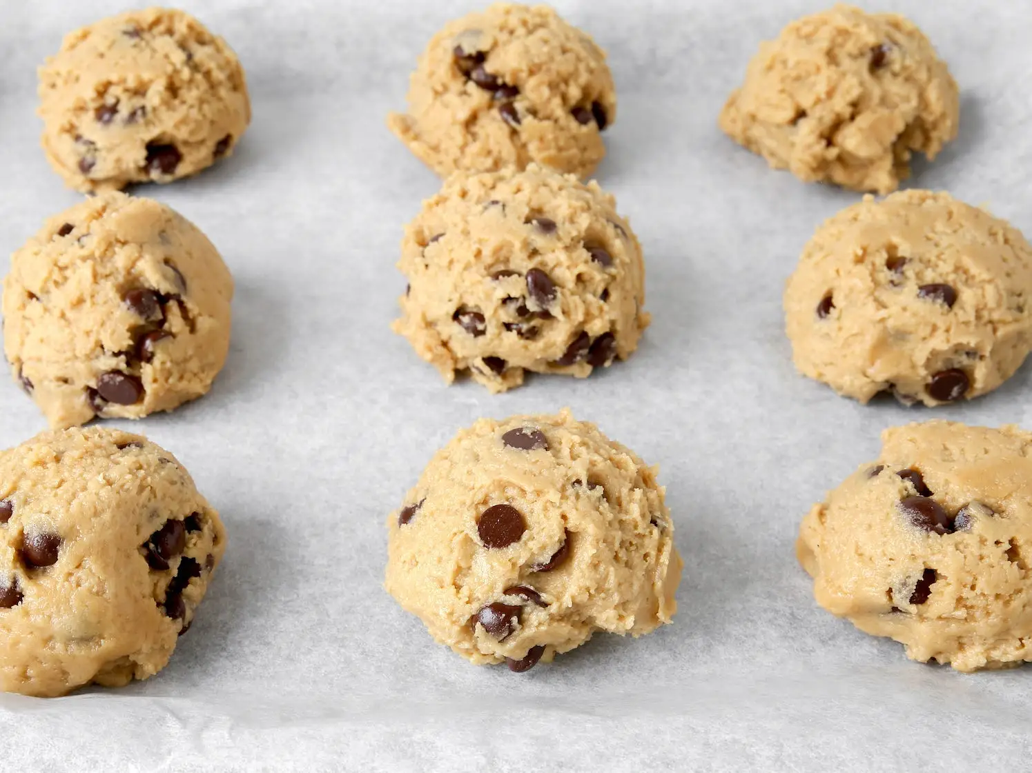 Balls of cookie dough on parchment paper